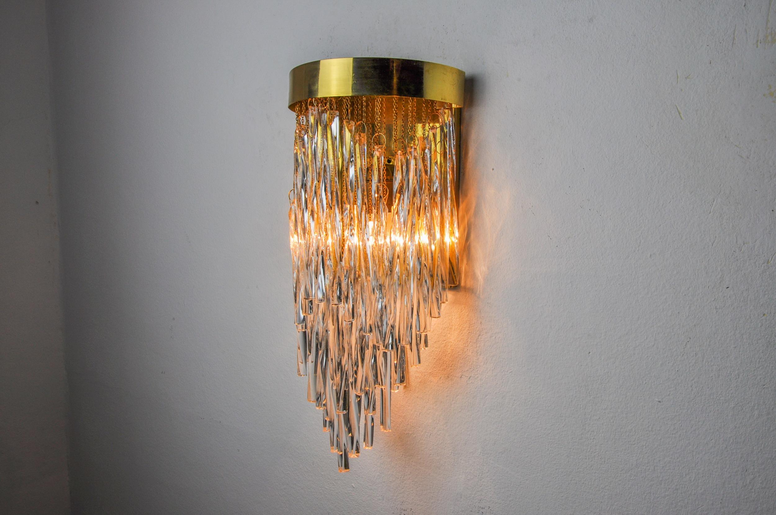Superb and rare Venini waterfall wall light designed and produced in Italy in the 1970s. Wall light made up of murano glass rods distributed in a cascade on a brass structure. Magnificent decorative object which will illuminate your interior