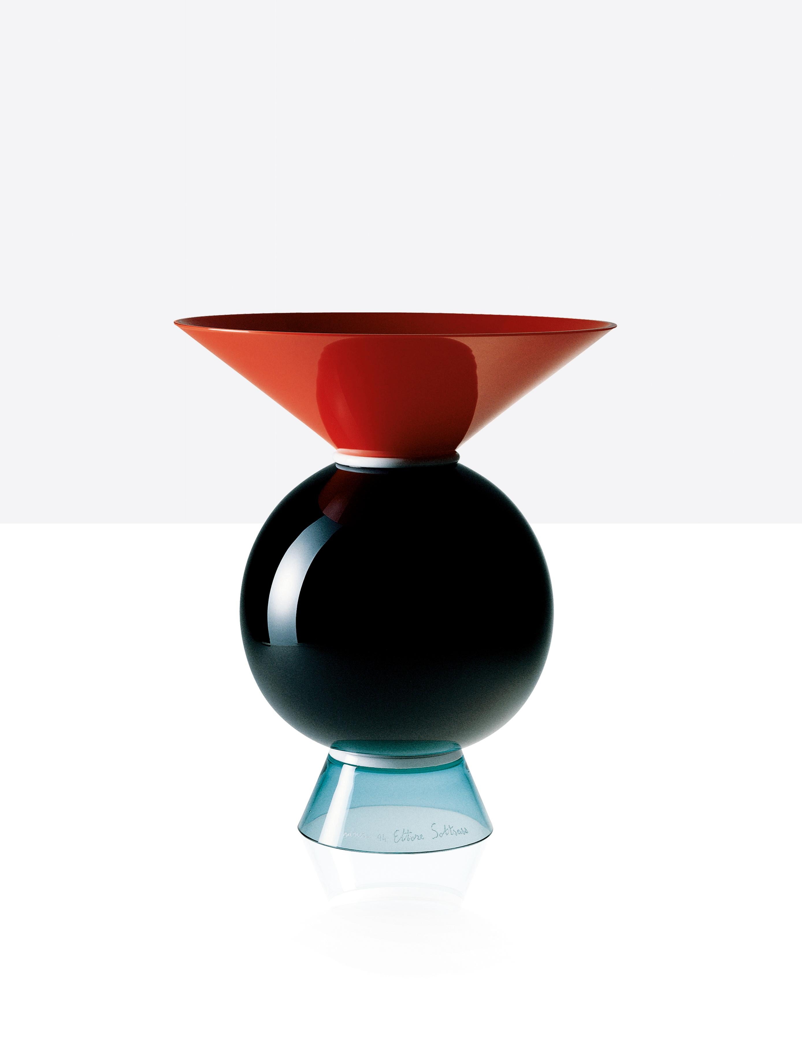 Venini glass vase with geometric, circular shaped body and triangular neck and base. Designed by Ettore Sottsass in 1994. Featured in coral red, milk-white, black and light green colored glass. Perfect for indoor home decor as container or strong