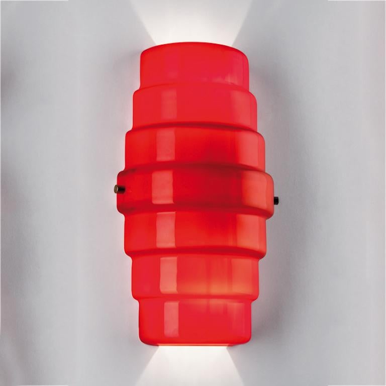 Zoe wall sconce in red glass. Its shape is reminiscent of a lantern and brightens any living space with its bold red color. 

Light source: Halogen 1 max- 70 W E27. Dimensions: 20 cm D x 20 cm W x 36 cm H.