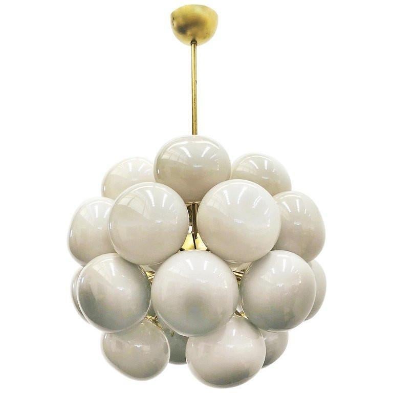 Lampadario Sputnik italiano con 24 paralumi in vetro di Murano color crema montati su una struttura in ottone / Disegnato da Fabio Bergomi per FABIO LTD / Made in Italy
24 luci / tipo E12 o E14 / max 40W ciascuna
Diametro: 28 pollici / Altezza: 39