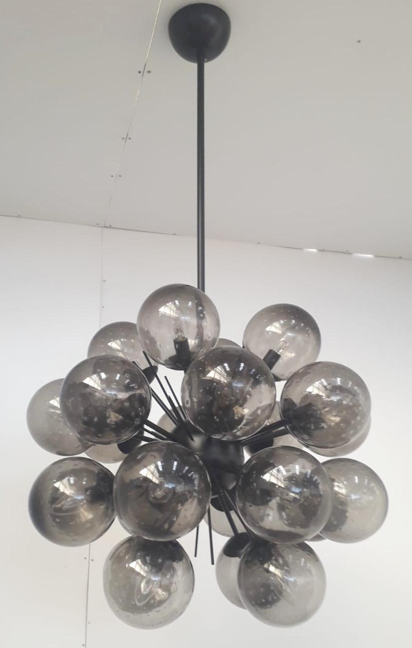 Lampadario sputnik italiano con 24 globi in vetro di Murano montati su una struttura in metallo verniciato a polvere nero opaco / Disegnato da Fabio Bergomi per Fabio Ltd / Made in Italy
24 luci / tipo E12 o E14 / max 40W ciascuna
Diametro: 28