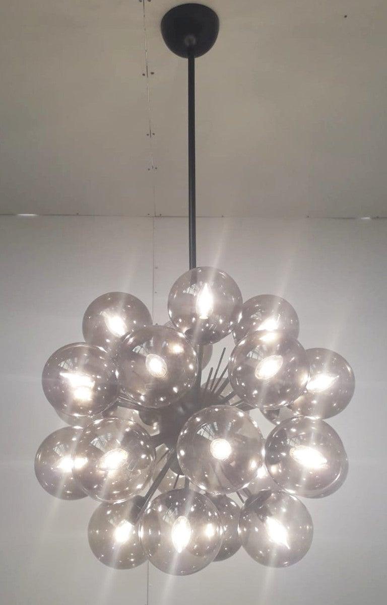 Lampadario sputnik italiano con 24 globi in vetro di Murano montati su una struttura in metallo verniciato a polvere nero opaco / Disegnato da Fabio Bergomi per Fabio Ltd / Made in Italy
24 luci / tipo E12 o E14 / max 40W ciascuna
Diametro: 28