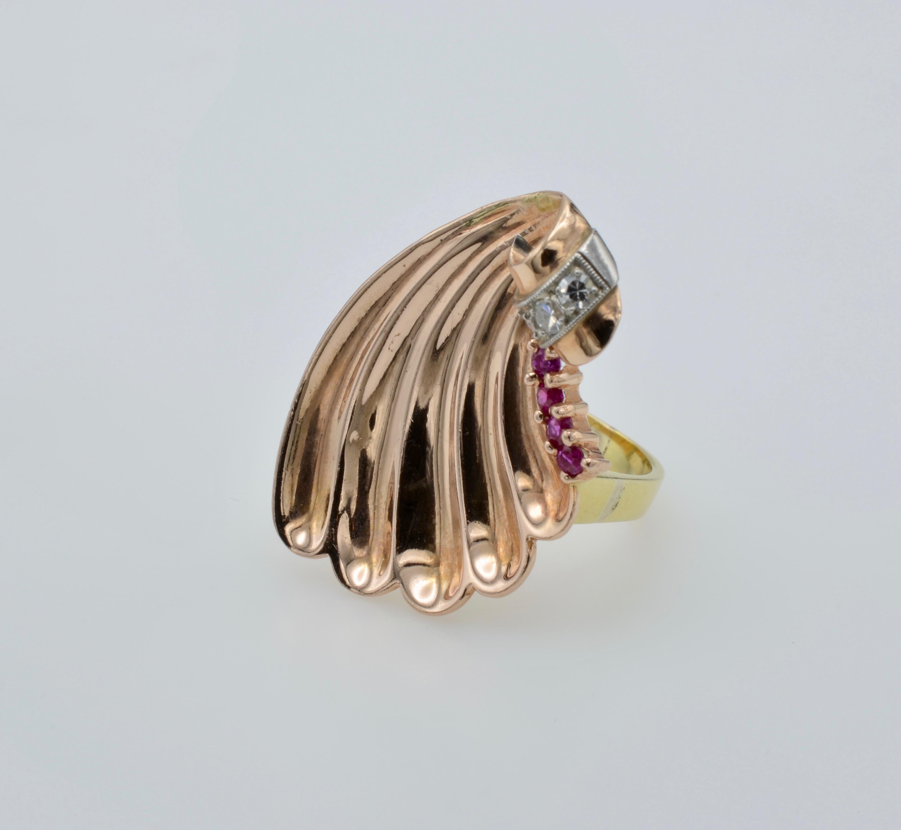 This Baroque Revival statement ring is a gorgeous flowing seashell adorned with rubies and diamonds. The seashell is a soft rose gold with elegant movement like waves on top of a yellow gold band. With feminine poise this ring looks as if Aphrodite