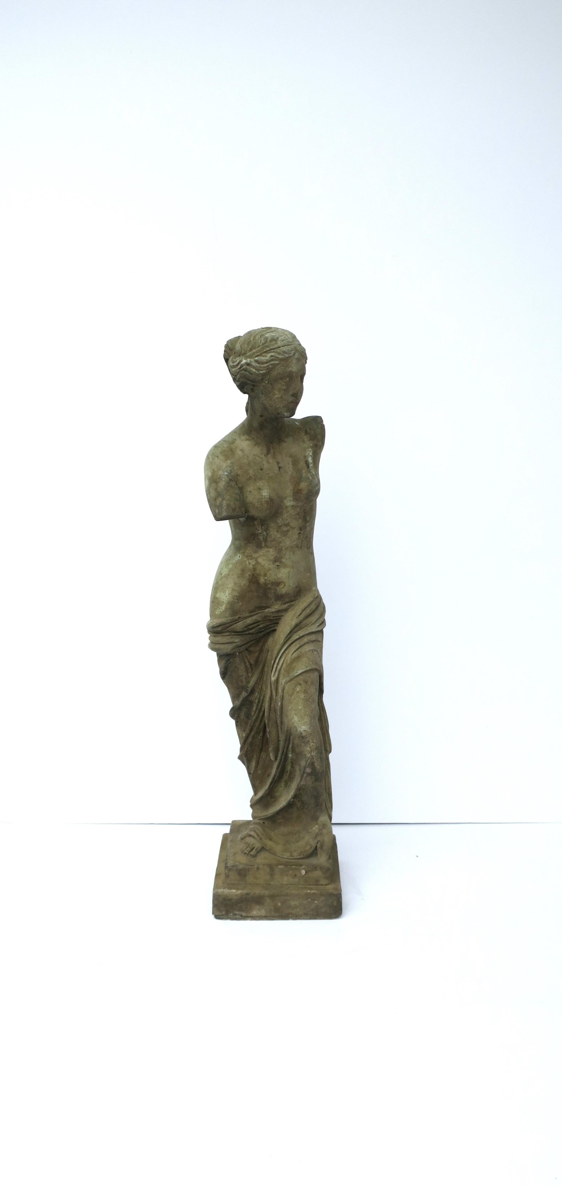 A beautiful Venus de Milo female figurative cast stone statue sculpture piece, in the Neoclassical style, circa 20th century. A great statement piece indoors on a column pedestal, cocktail table, etc., or outdoors, a garden or patio area, pool