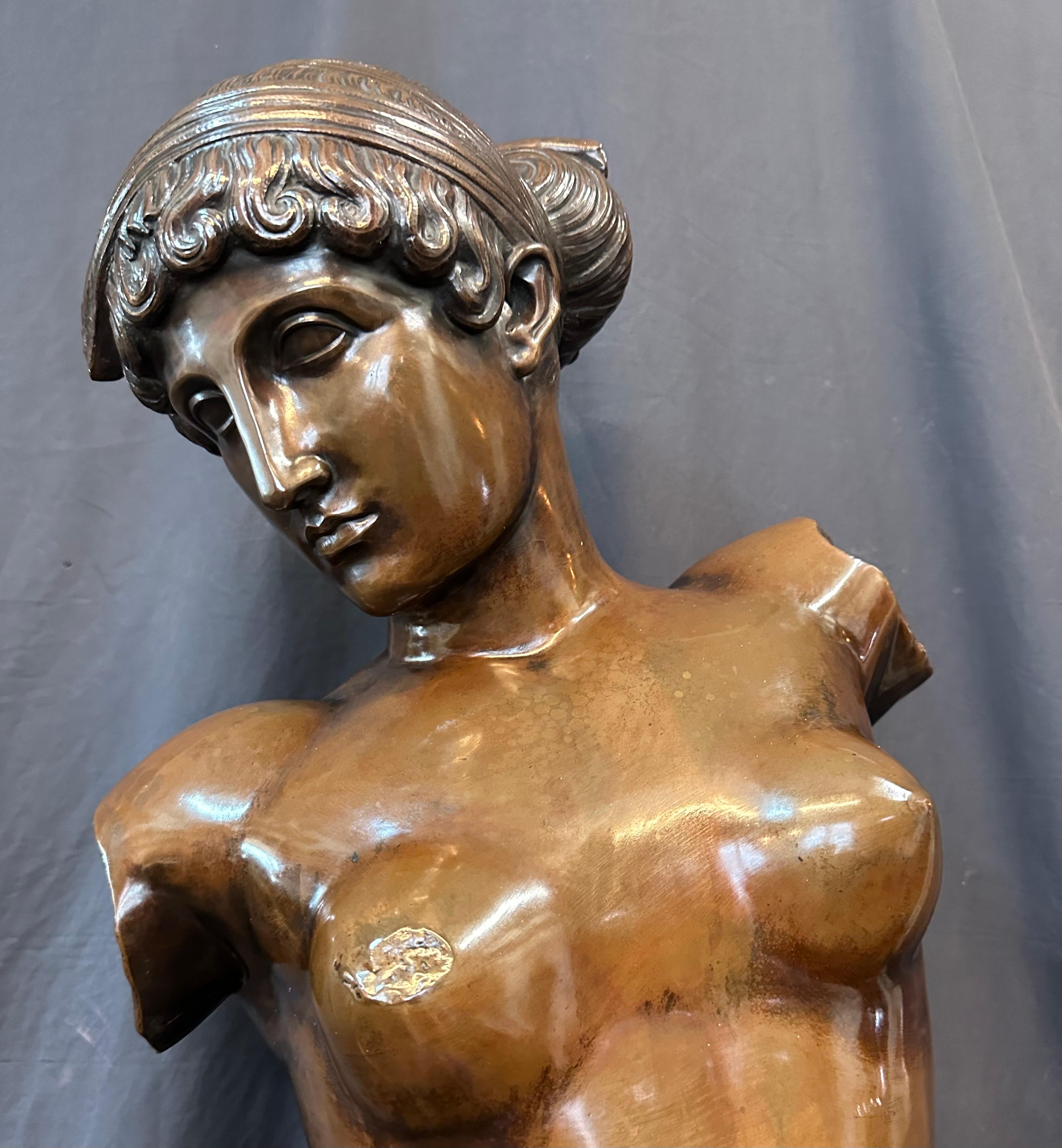 This vintage full figure patinated replica of a Roman goddess (? Venus) dates from the mid twentieth century. The statue is positioned standing alongside her gown & urn. The base is signed with a foundry mark. It is a Roman copy from a 1st century