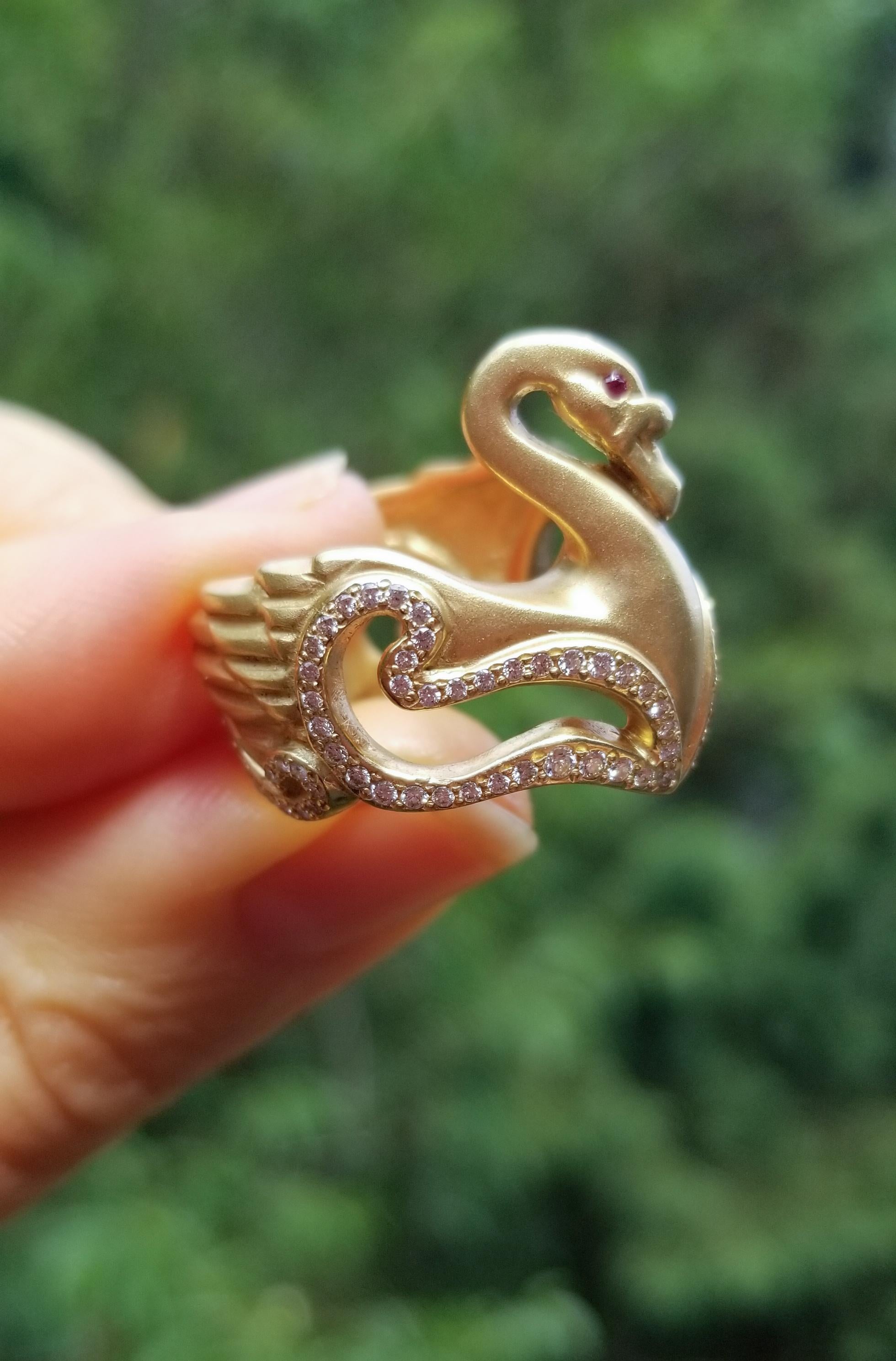 18ky gold, diamonds inlaid in waves, pink sapphire eyes

Like the goddess Venus, this graceful beauty rises from the water.
Believed by the goddess of love to be sacred, the swan represents grace and beauty.
Floating through sparkling