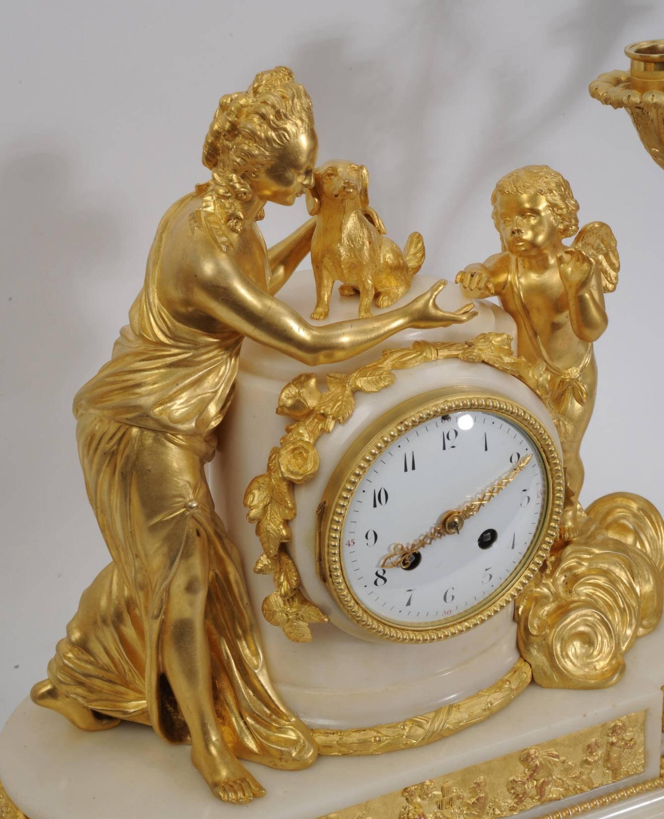 A large and exceptional original antique French ormolu and marble Louis XVI style clock set. The beautiful young Venus stands with a small dog, a symbol of fidelity. Amour is represented in the heavens by a putto standing amongst the gilded clouds.