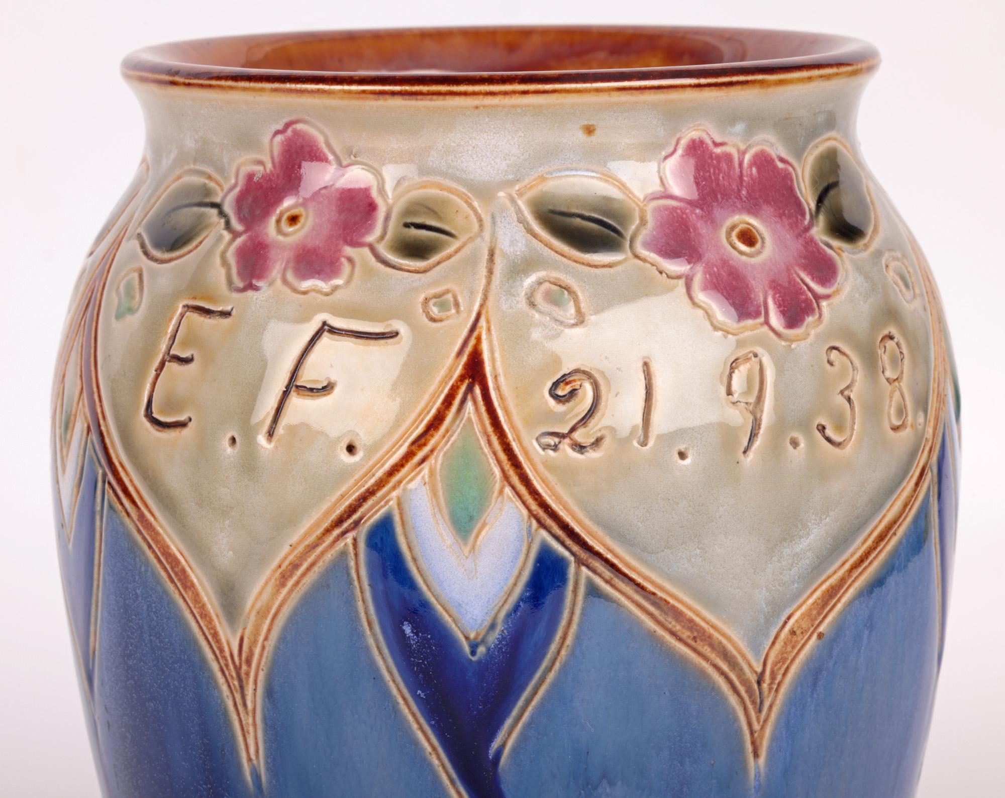 Un grand et impressionnant vase de présentation Art déco Doulton Lambeth à décor floral réalisé par la célèbre artiste Vera Huggins et daté de 1938. Le grand vase en grès repose sur un pied étroit à jupe ronde, avec un large corps bulbeux au col