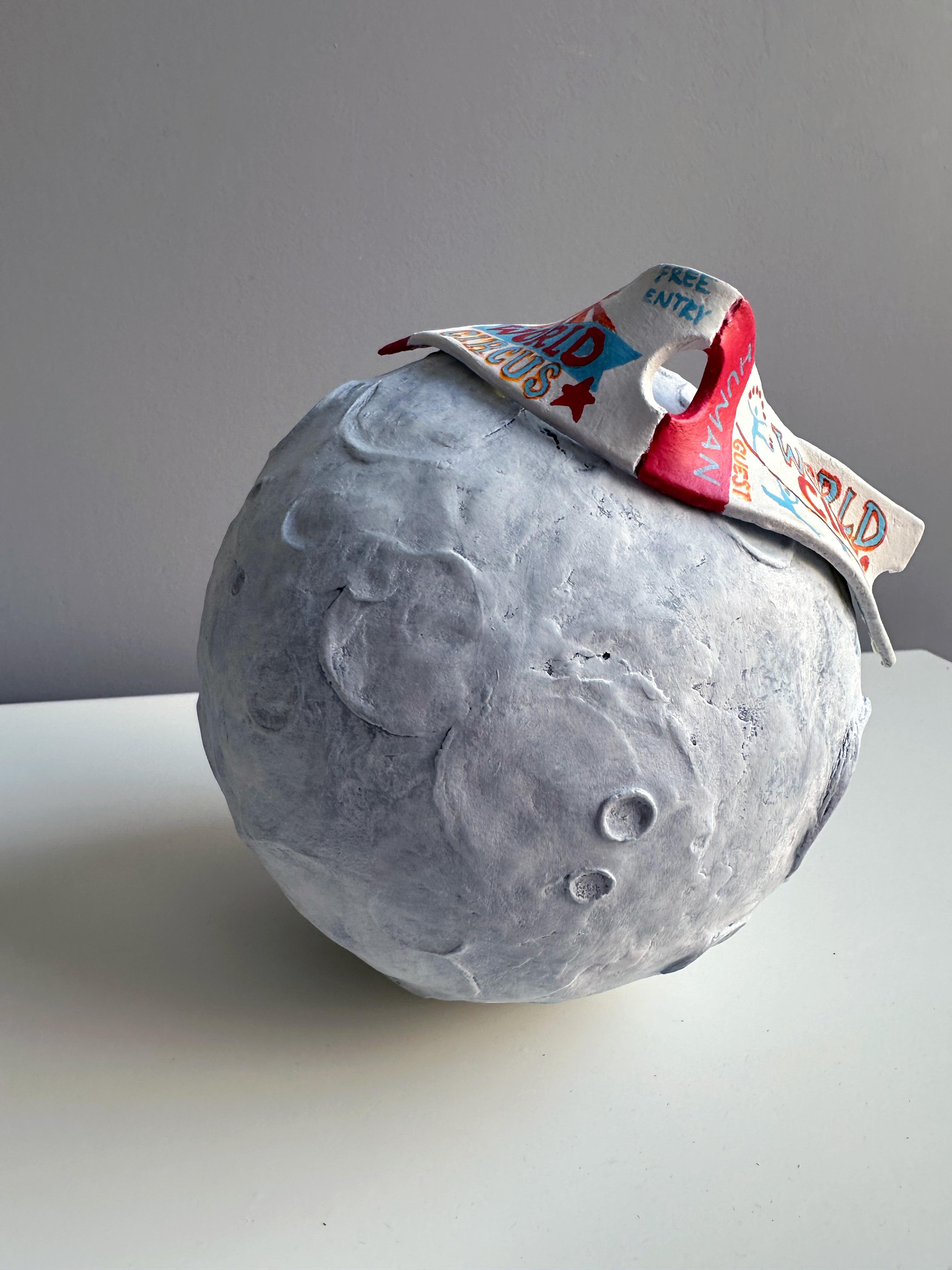 Luna Park is a mixed-media moon wall sculpture in foam clay and acrylics that recontextualizes lunar texture as a small stage for intimate narrative. This moon wall sculpture, executed in foam clay and hand-painted acrylic, combines tactile relief