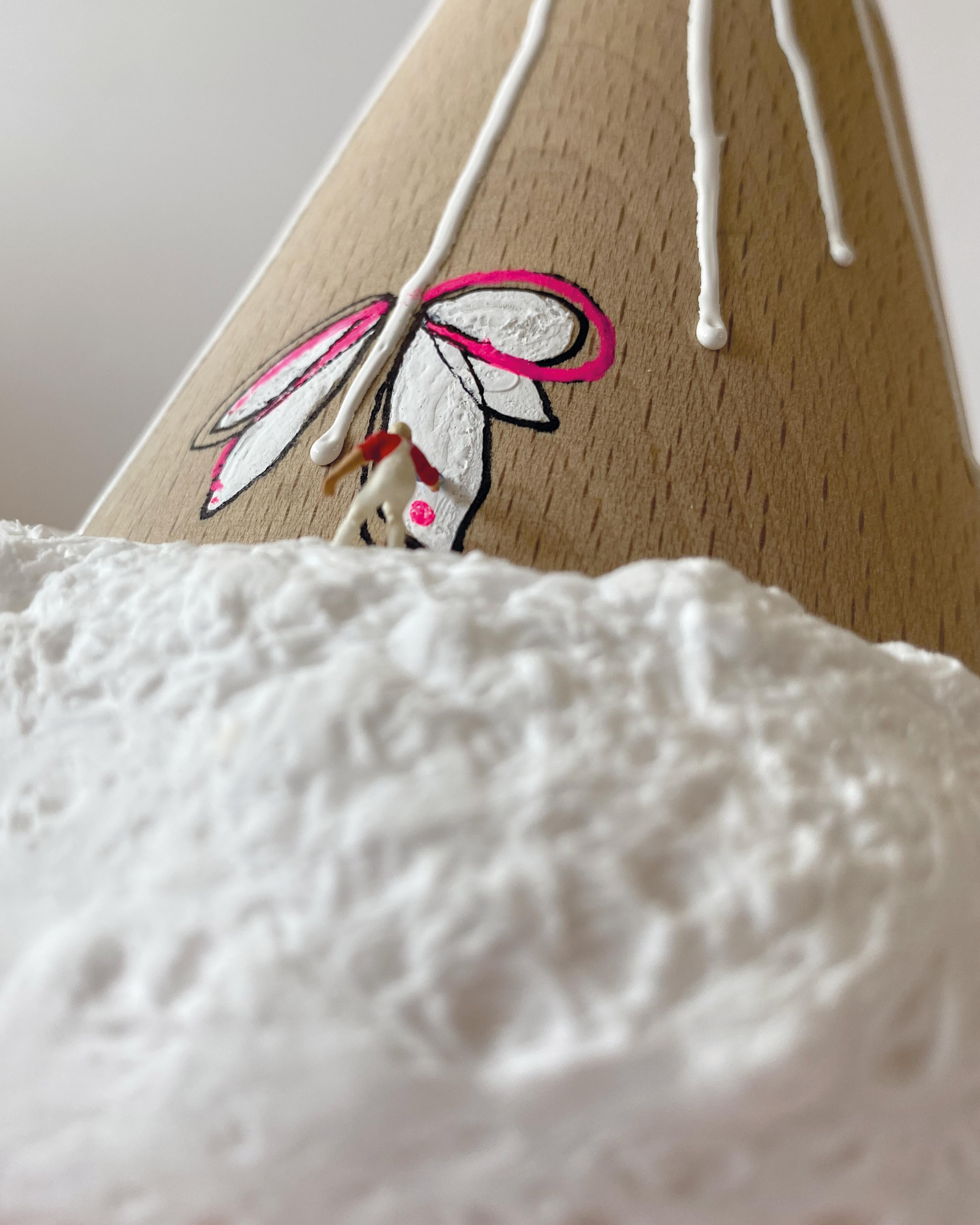 DULZURA es una escultura pop contemporánea de Vera Vizzi que combina arcilla espumosa, esmalte, rotuladores acrílicos y madera de abeto en una composición compacta y caprichosa. La pieza, que mide 18 × 18 × 13 cm, tiene una forma cónica que recuerda