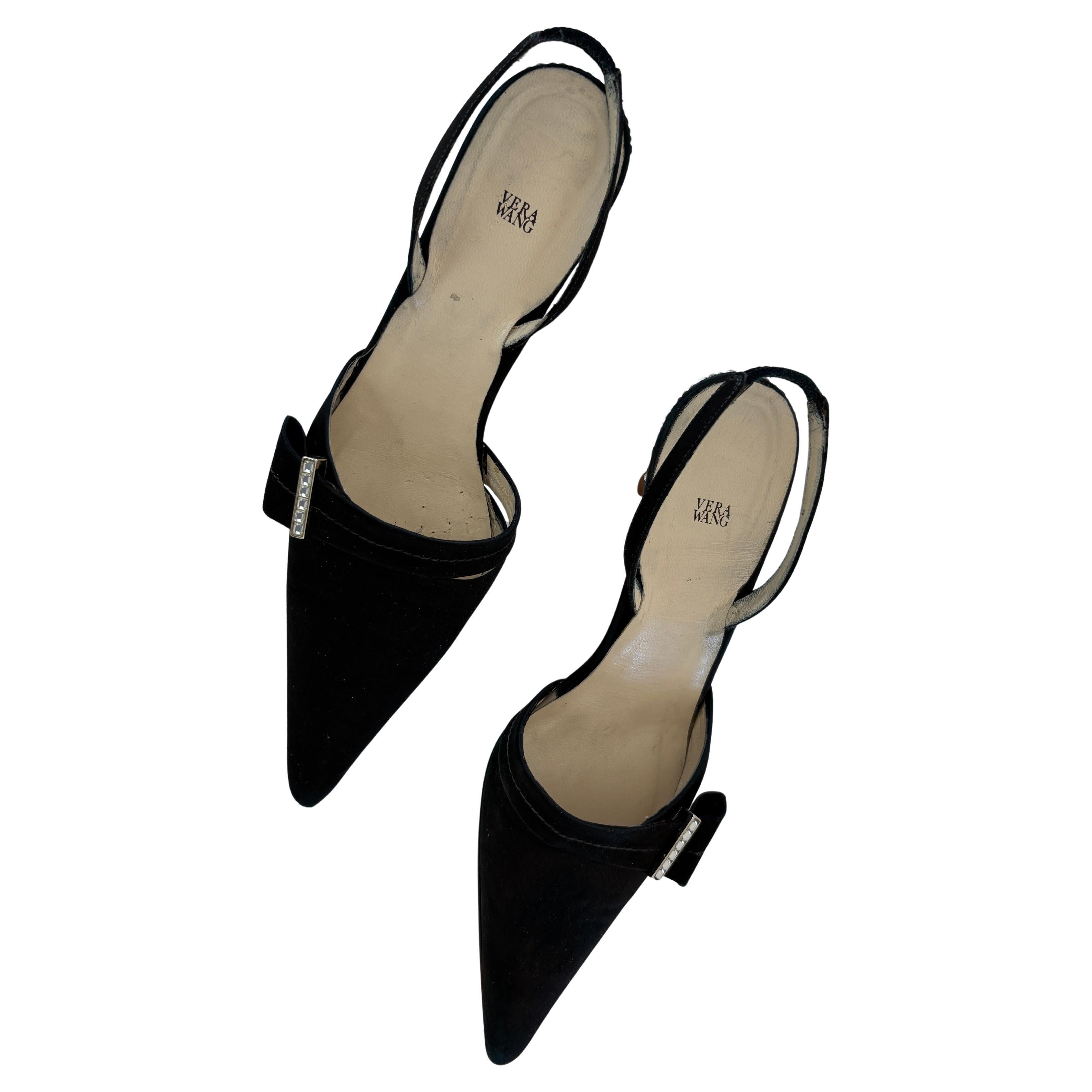 Vera Satin noir avec strass
Escarpins classiques et élégants en satin noir de Vera Wang, ornés d'une délicate broche en cristal sur un ruban de satin noir sur le dessus de la chaussure.
Boucle en cristal à la cheville, cristaux en strass sur les