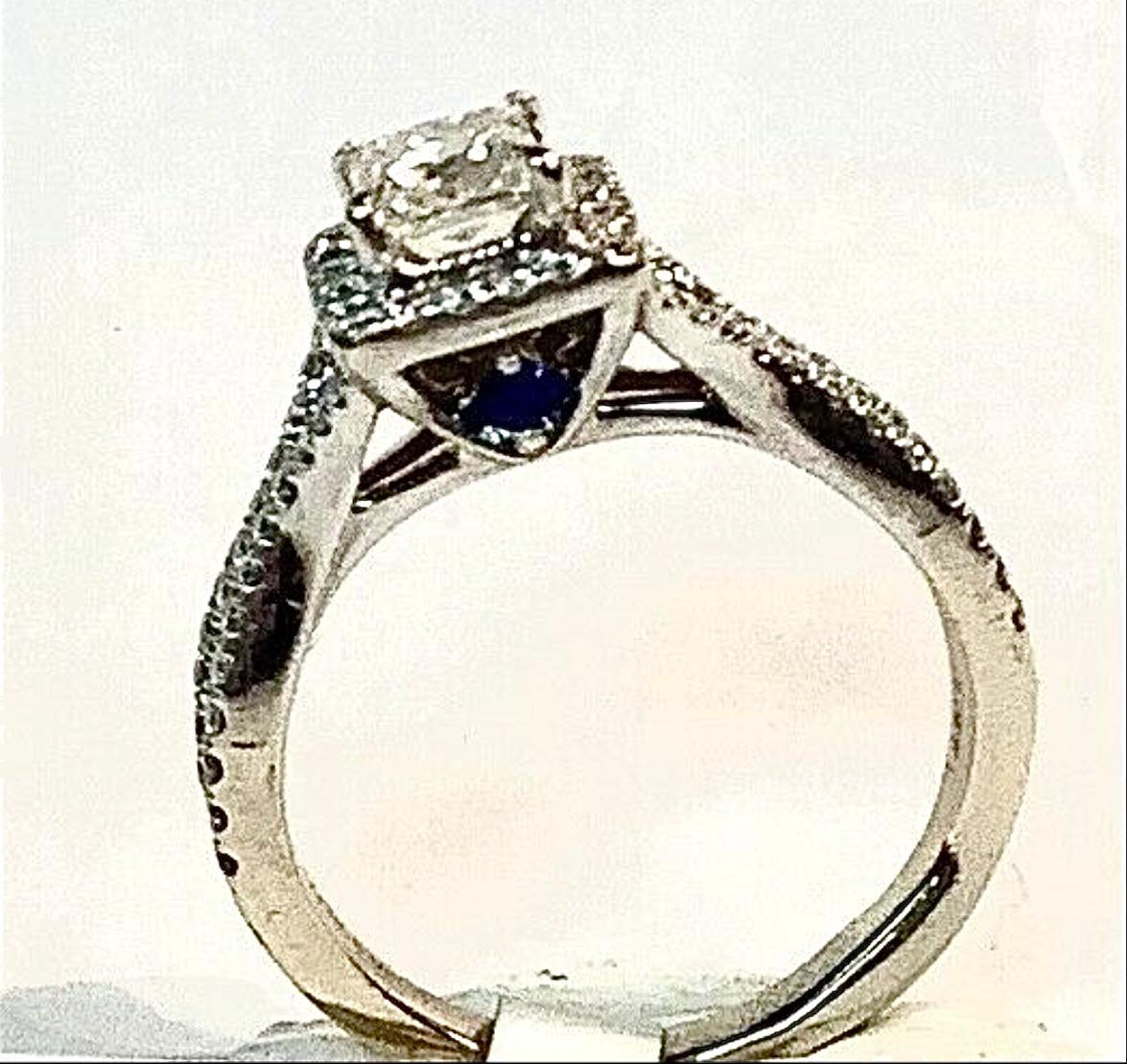Beautiful 14K White Gold Vera Wang Diamond engagement ring with two small sapphire stones from the Vera Wang Love Collection. The two sapphire stones stand for faithfulness and everlasting love.  4.33 Grams TW. The dimension of the emerald cut