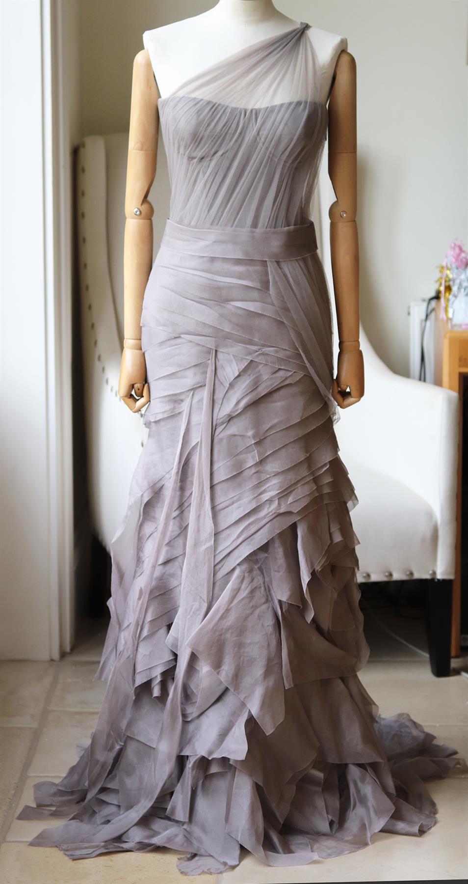 One of Vera Wang's extravagant, layered looks, made from cascading tiers of silk-organza, it has a draped one shoulder silhouette over a boned bodice, the fabric is so light, it falls to an ethereal train - when you walk, it appears to float. Taupe