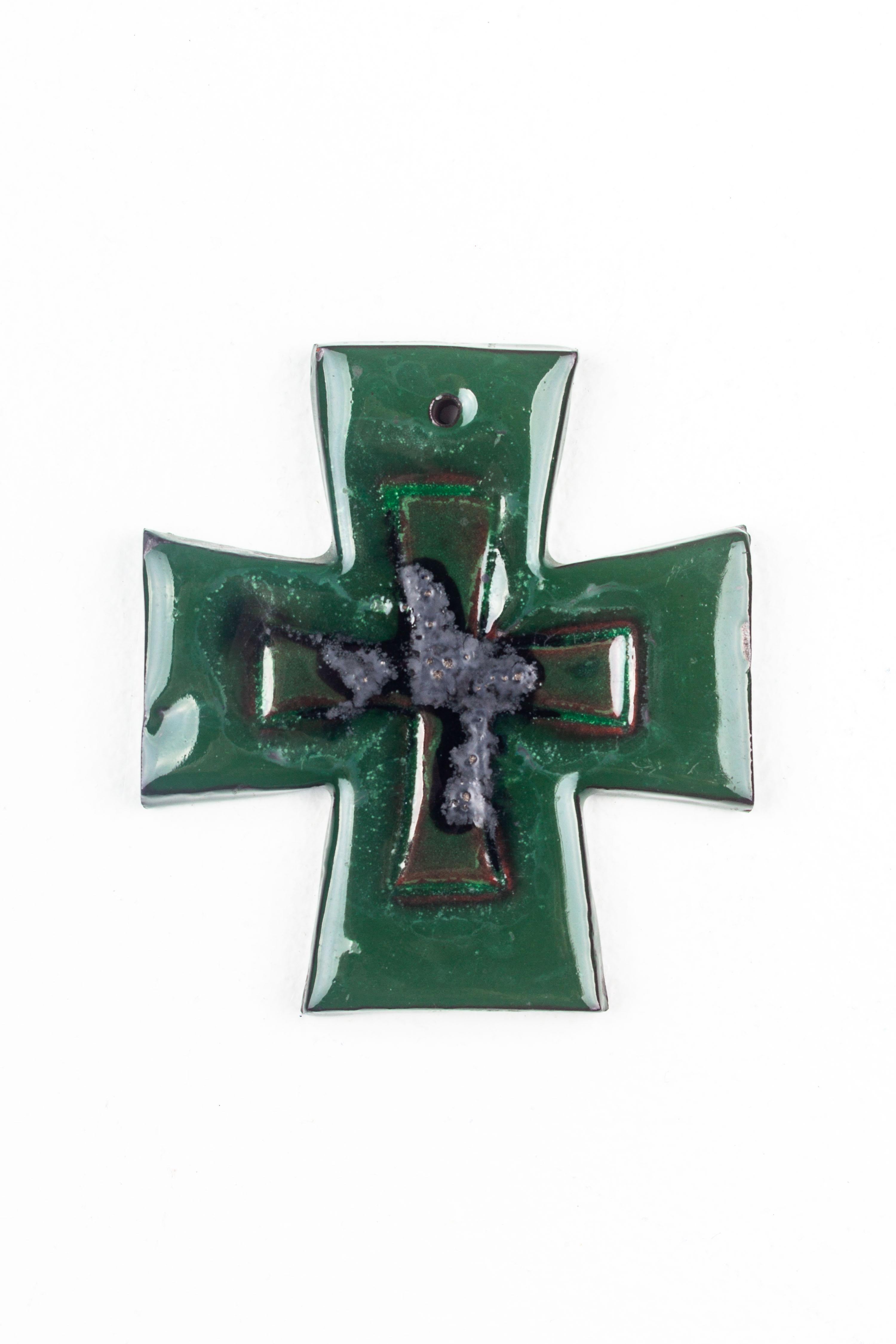 This robustly glazed ceramic Maltese cross represents the confluence of religious symbolism and mid-century modern aesthetics, crafted by the hands of European studio pottery artists. The cross is characterized by its equilateral arms and a deep,