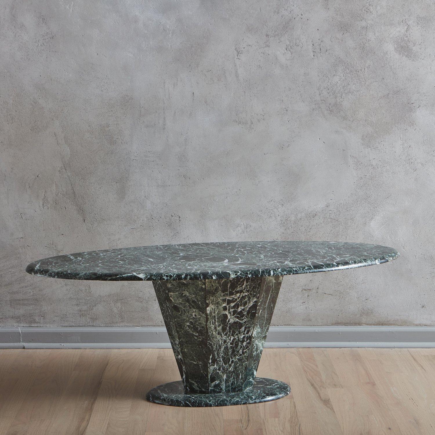 A vintage verde marble coffee table in a rich emerald hue with beautiful white veining. This piece features an oval table top with a demi bullnose edge and a faceted, tapered pedestal base. Unmarked. 20th Century.

