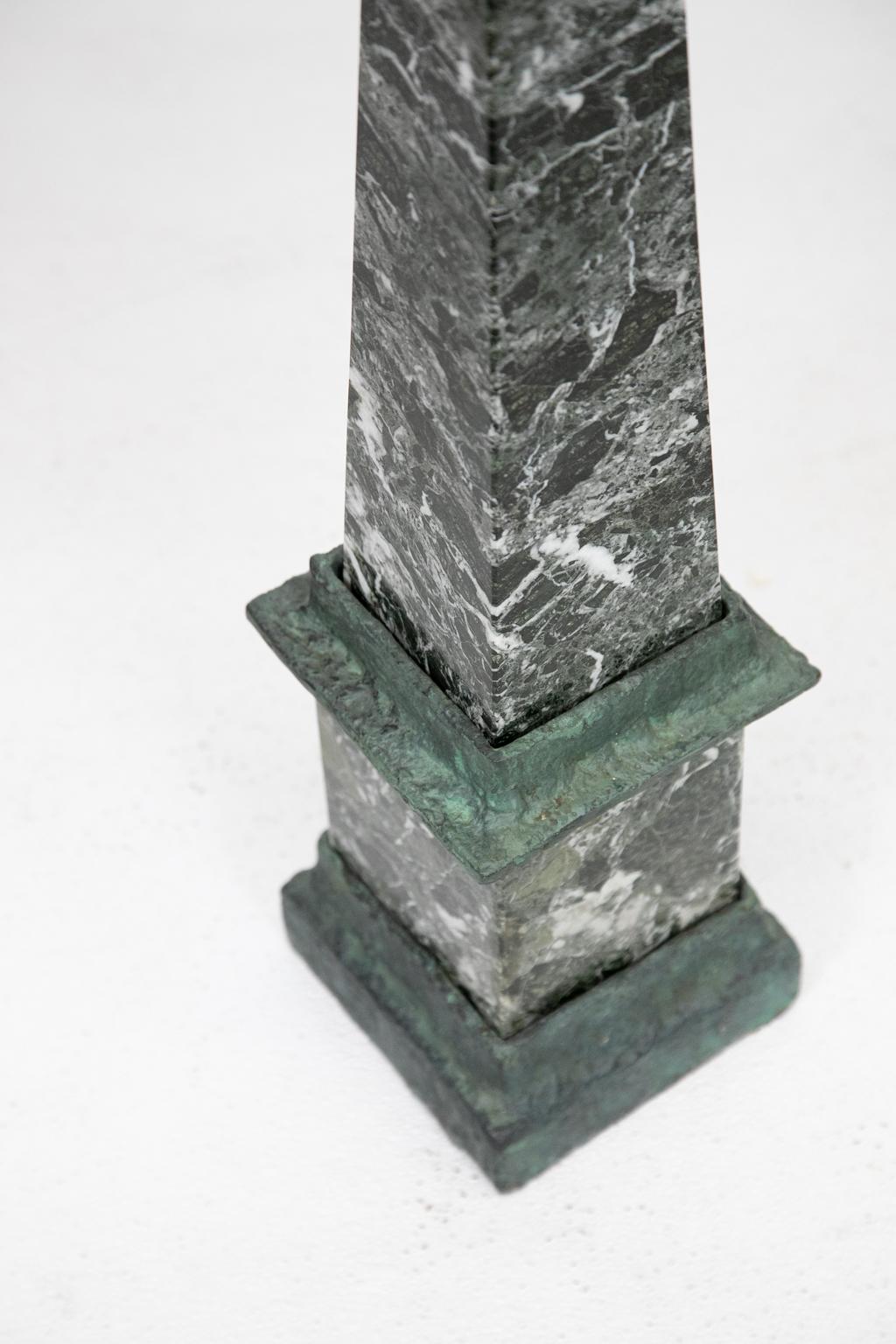 Verde marble obelisk, the base and apron are carved stone surrounding the dark green marble with white veining.


   