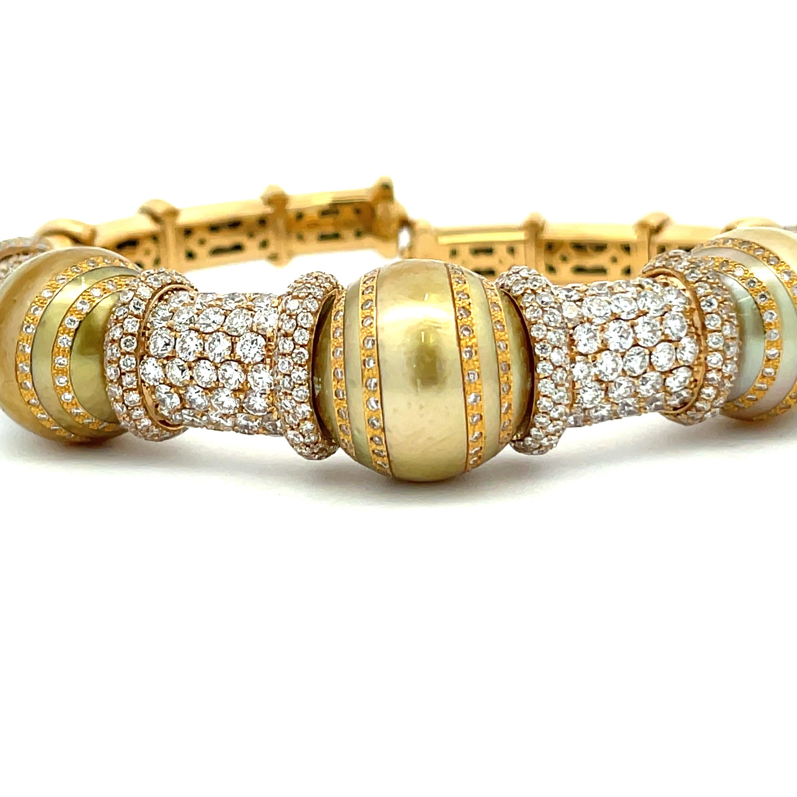 VERDI, 18 Karat yellow gold bangle featuring three Golden South Sea Pearls measuring 14-15 mm flanked with diamonds throughout weighing 8.58 Carats.  
8.58 cts
