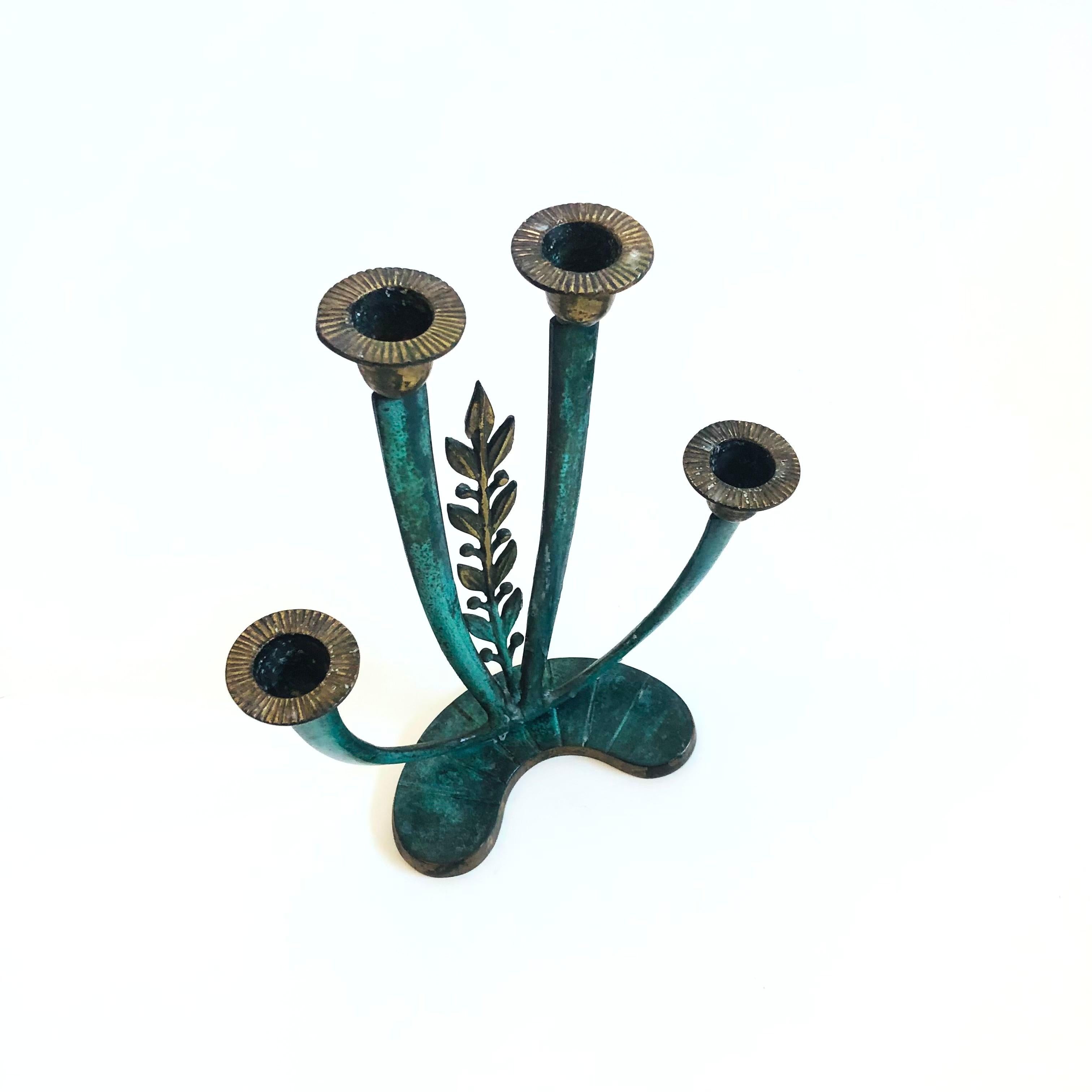 A vintage brass candle holder with a beautiful vertigris patina. Lovely leaf detailing in the center. Can hold 4 standard taper candles. Made in Israel.

