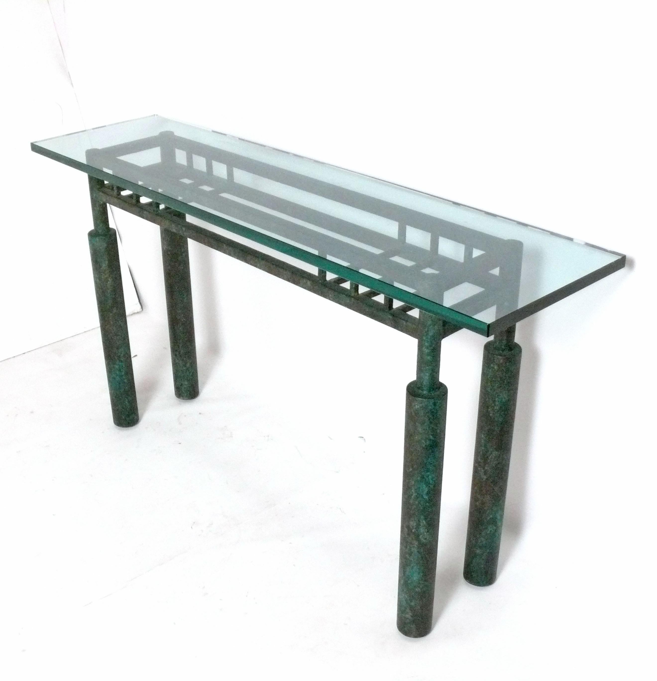 Table console en métal à finition bronze vert-de-gris, américaine, vers les années 1980. De taille polyvalente, elle peut être utilisée comme console ou table de canapé, table média ou TV, ou encore bar. Il mesure 60