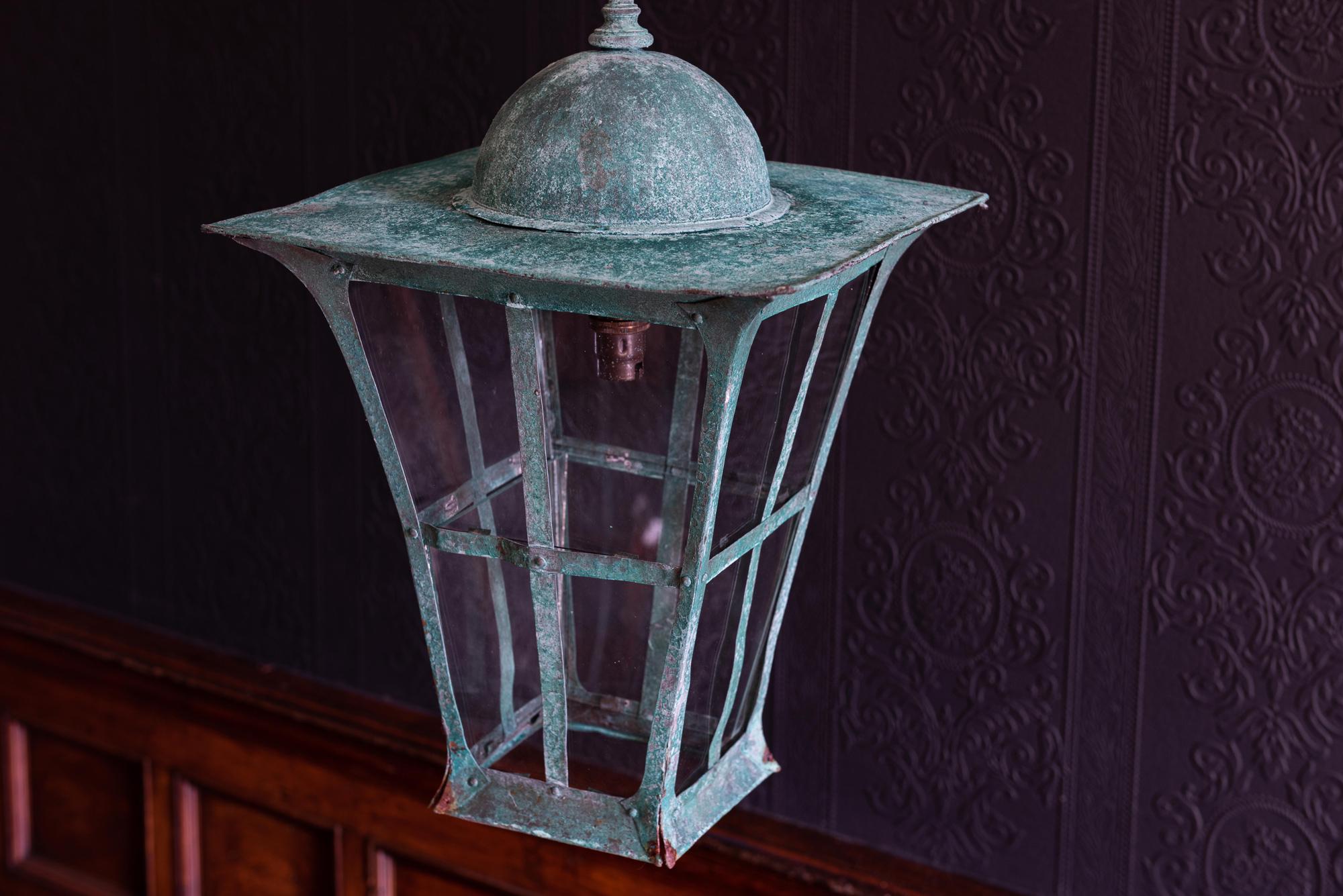 Verdigris copper Arts & Crafts lantern,
circa 1900.

Riveted copper.

With 1m of silk flex, 1m of heavy gauge antique brass chain and bronze ceiling hook

Re-glazed rewired and pat tested - ready to hang.

Measures: 66 H (to ring) x 30 D x