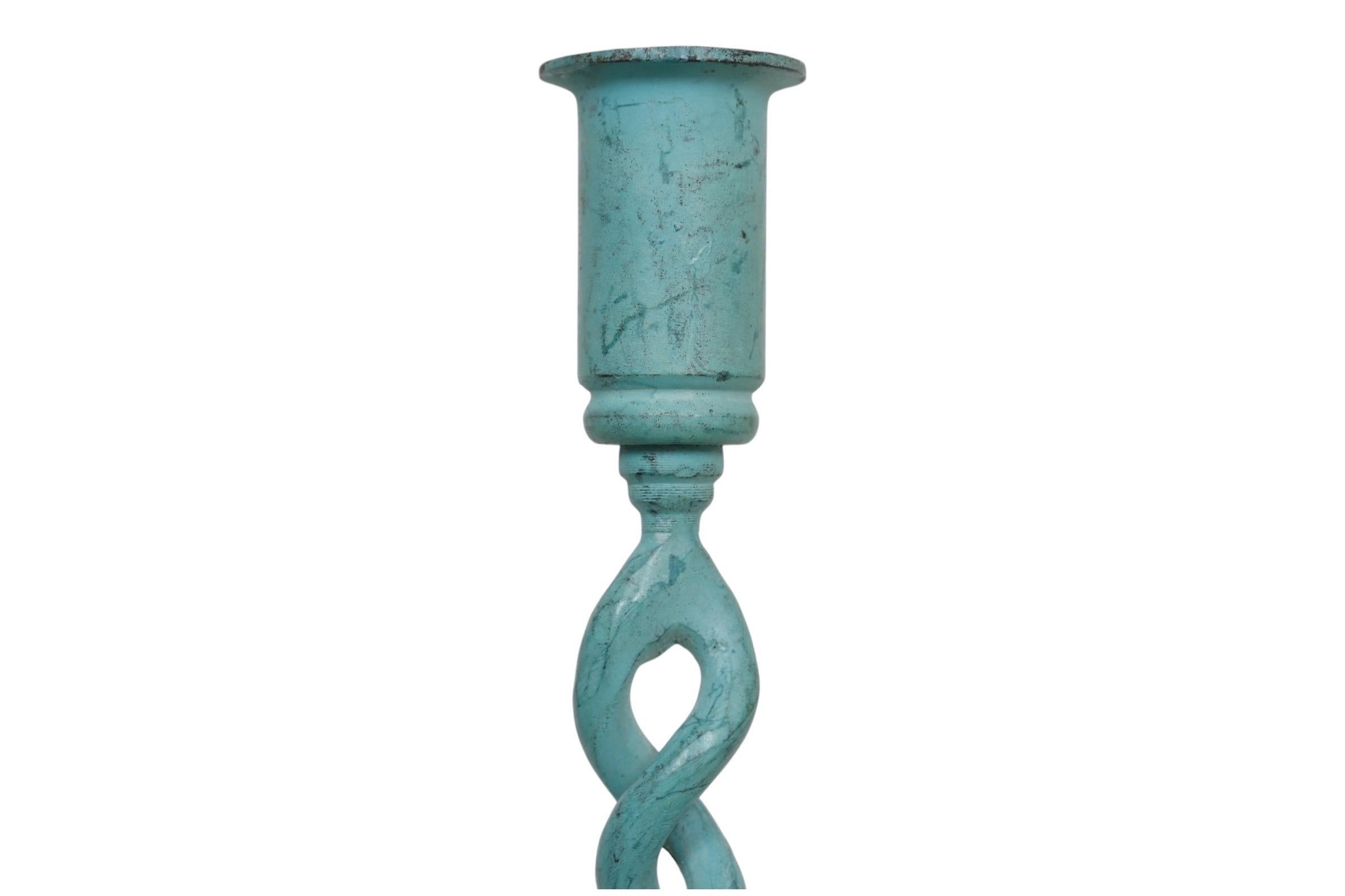 A pair of verdigris candlestick holders. Simple capitals are supported with open barley twist columns, finished with round finely stepped bases. Dimensions per candle holder.