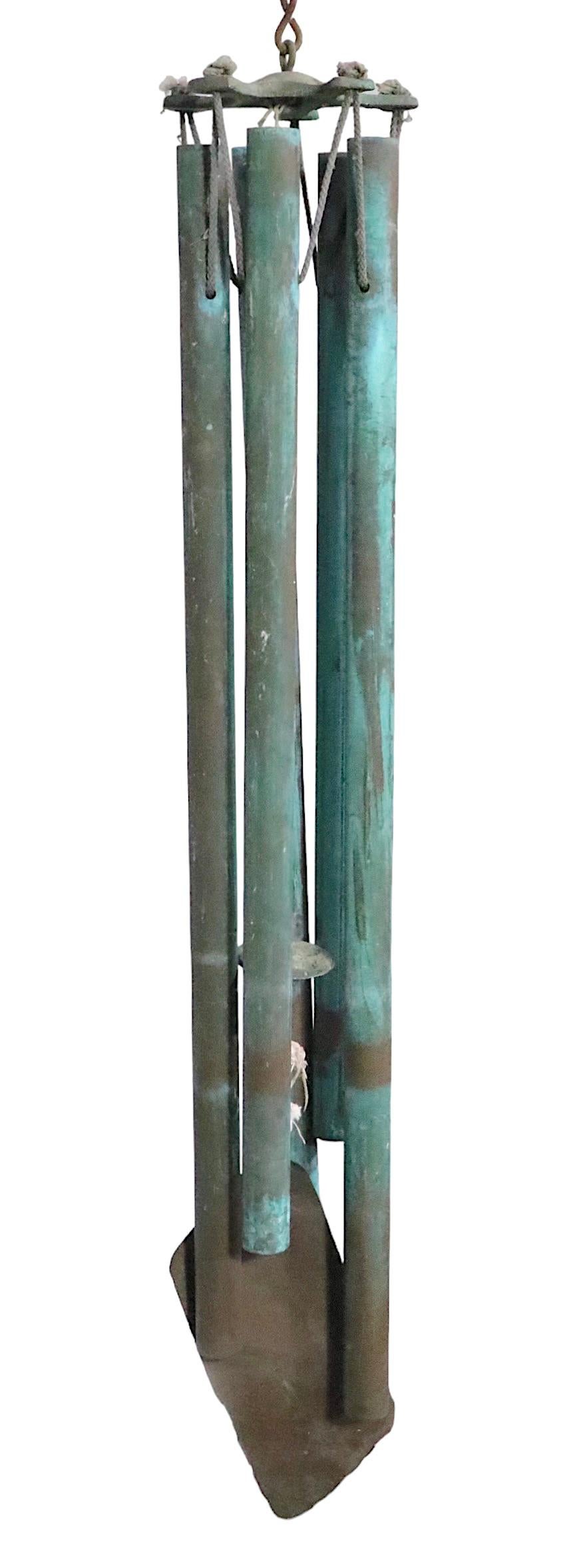 Brutalist Verdigris bronze wind chimes from the 1970's. This intriguing chime features five hanging pipes of various lengths, which create a calming tone when the wind blows. Perfect Mid Century, Brutalist style addition to your meditative outdoor