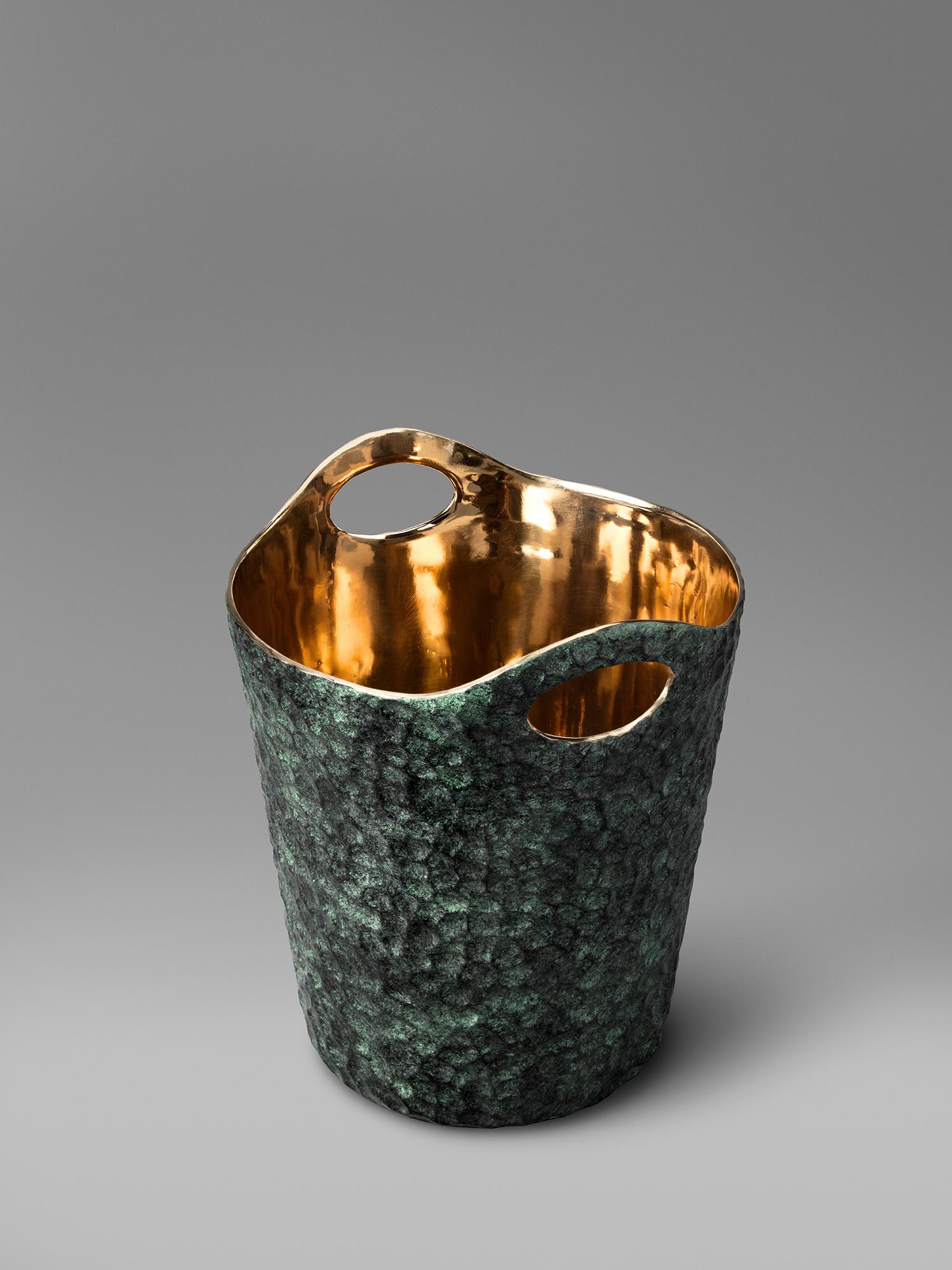A bronze wine bucket. The smooth wrought surface of the exterior has a beautiful Verdigris patina which contrasts brilliantly to the high shine of the interior wall. It comfortably holds a magnum. We also think it makes for a great cachepot of