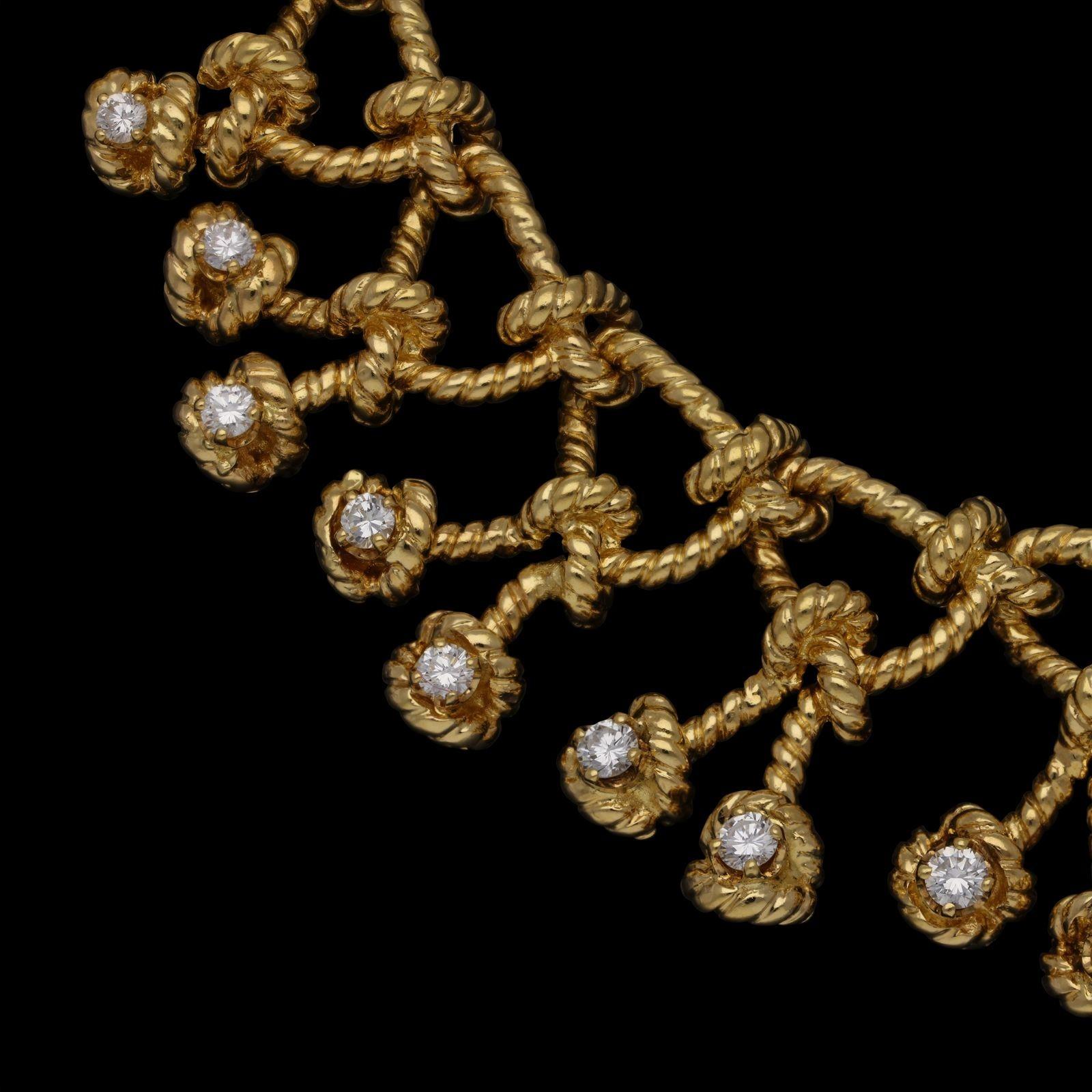 A beautiful gold and diamond ‘Regatta’ necklace by Verdura, c.1970s, the bib-style necklace of openwork design formed of 18ct yellow gold twisted rope work loop motifs each suspending either a single or double rope knot set to the end with a round