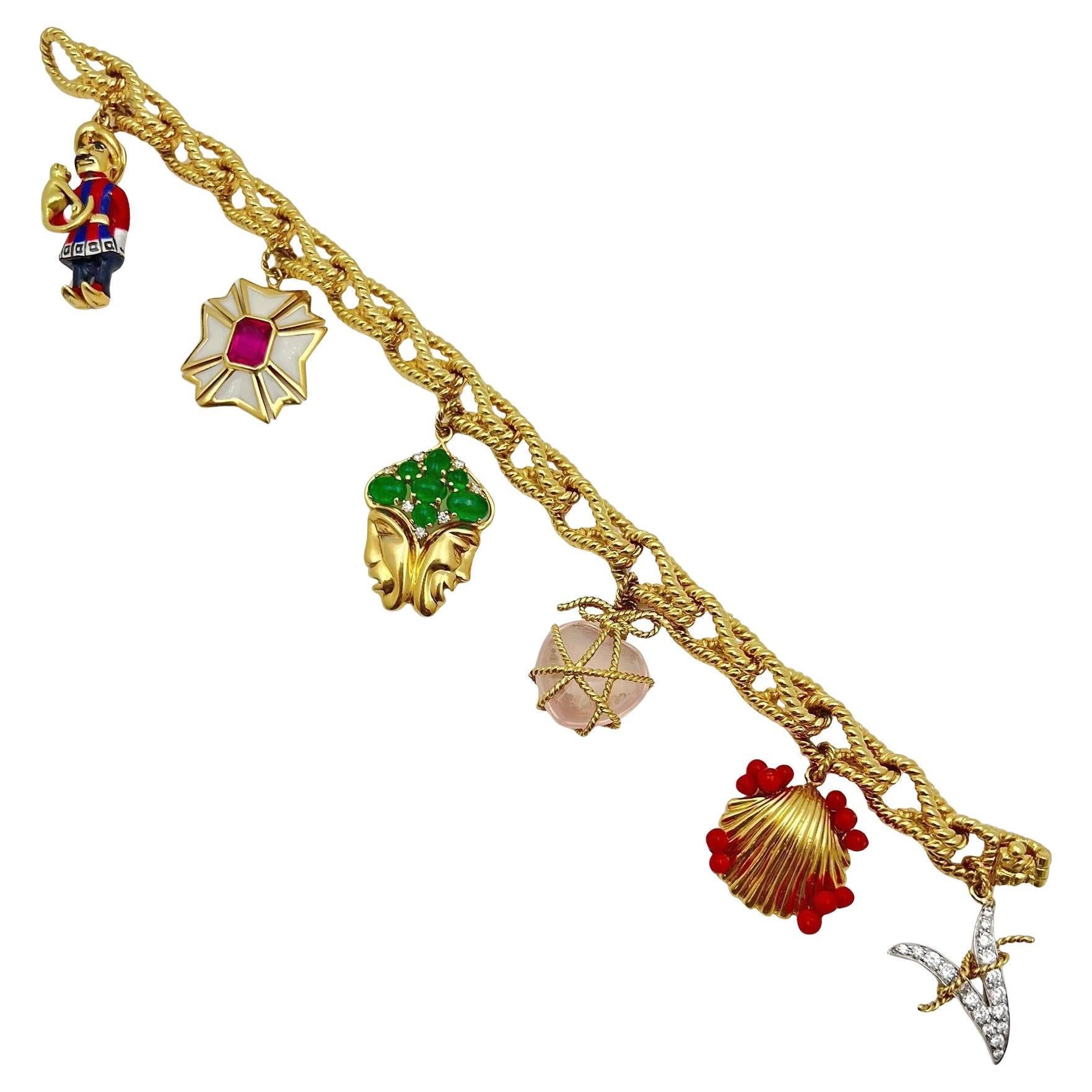Pulsera con colgantes Verdura Icon de oro amarillo de 18 quilates, con seis colgantes que incluyen:
Corazón de cuarzo rosa cabujón, envuelto en oro; concha de oro acentuada con cuentas de coral rojo natural; letra 