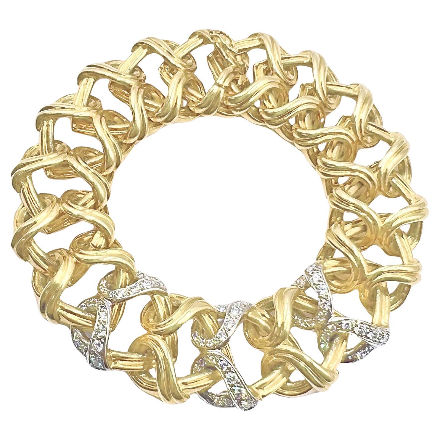 Verdura heart link bracelet in 18k yellow gold, comprised of seventeen interlocking open heart links with a polished finish.  The center is fashioned with three platinum loop sections accented by fifty-four round brilliant-cut diamonds weighing