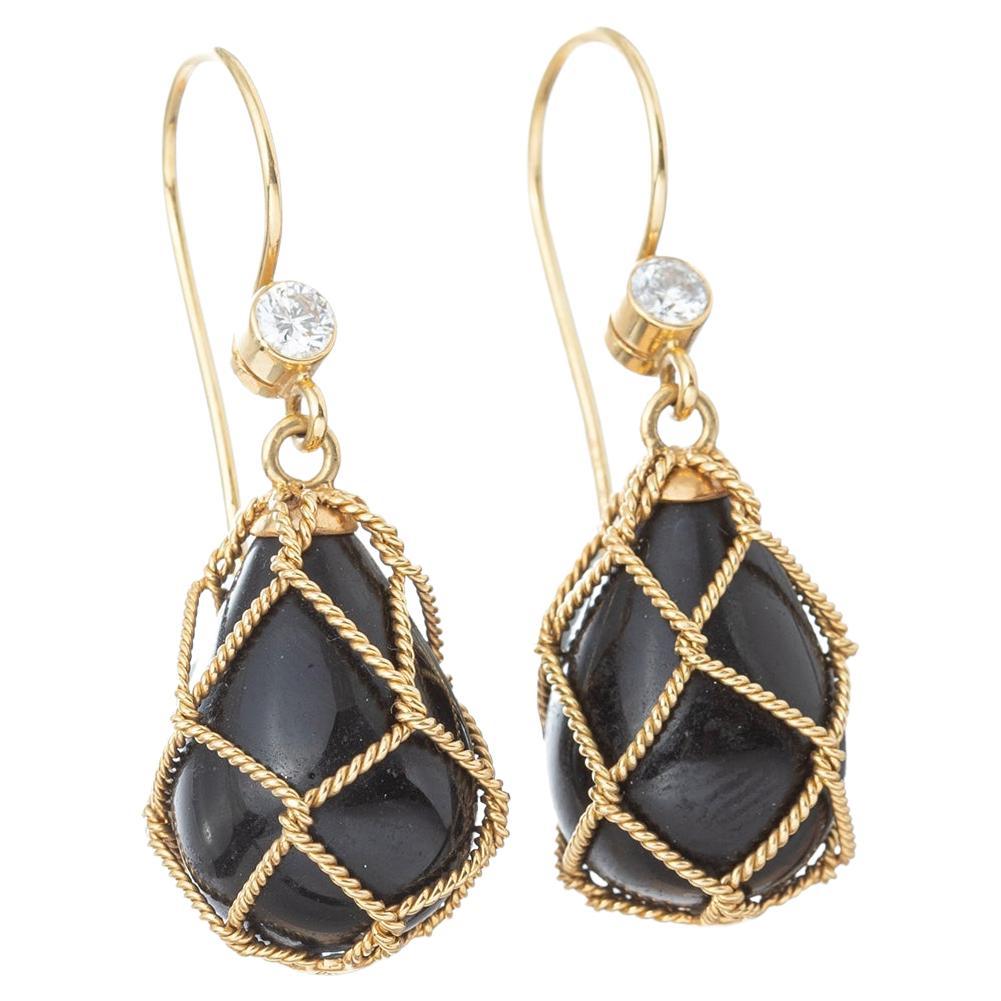 Drop earrings, each featuring a black onyx drop encased within a rope-twist 18k yellow gold 'net' and accented by a bezel-set round brilliant-cut diamond surmount.  Two diamonds weighing approximately 0.32 total carats.  Frenchwire tops for pierced