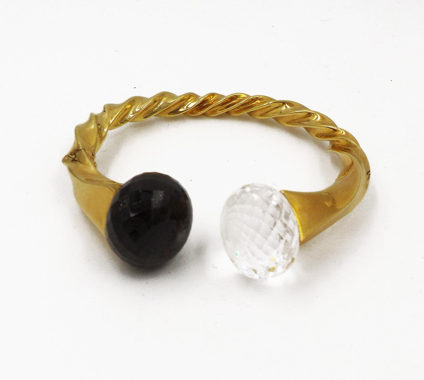 Composed of twisted gold set at the terminals with a faceted rock crystal and black spinel, internal circumference 6 inches, signed Verdura. Signed Verdura. Stamped 750 for 18 karat gold. Gross weight approximately 32 dwts. Inner circumference
