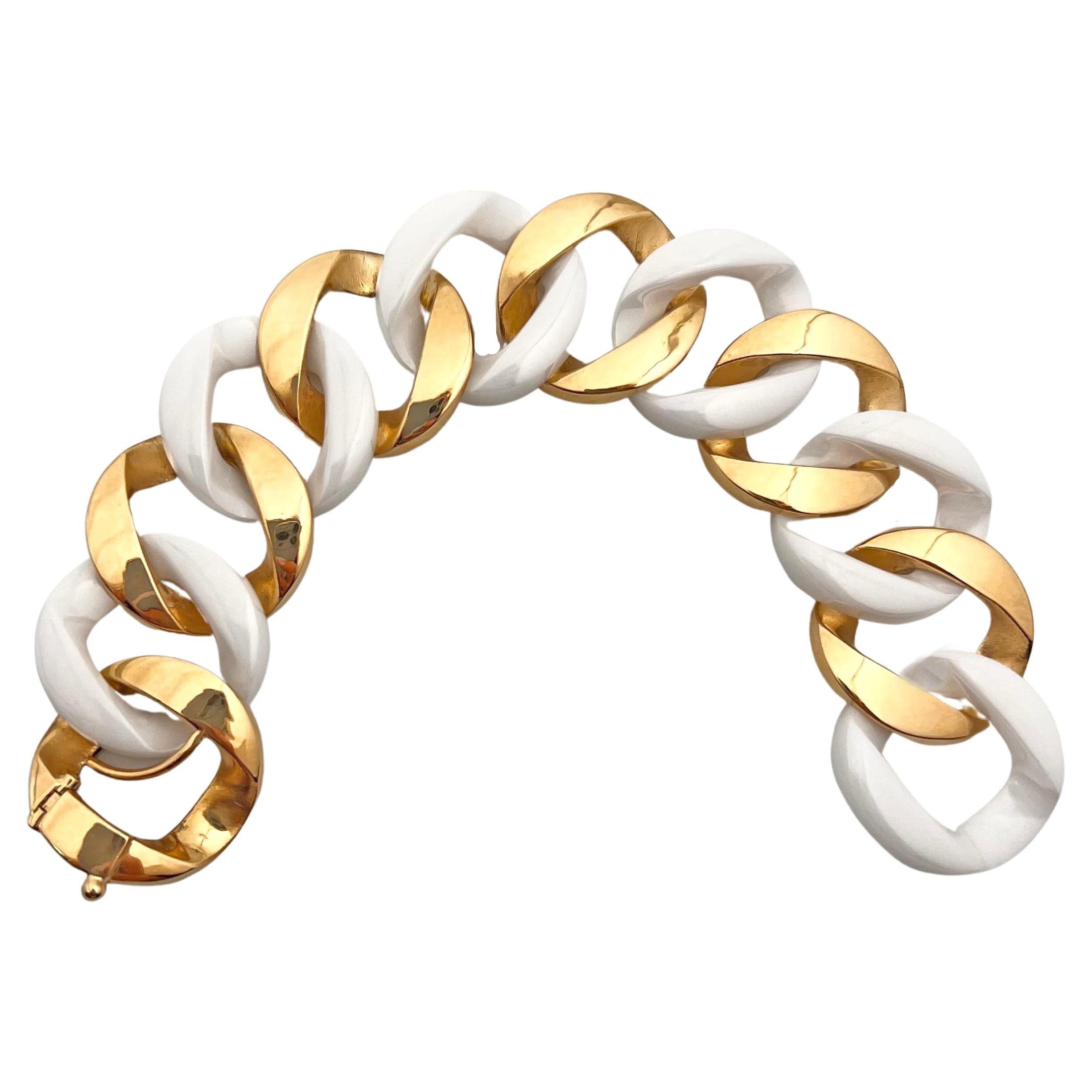 Elevate your style with the undeniable sophistication and timeless beauty of this Verdura 18 karat yellow gold and white ceramic curb-link bracelet. This exquisite piece showcases polished flat gold links alternating with white ceramic links,