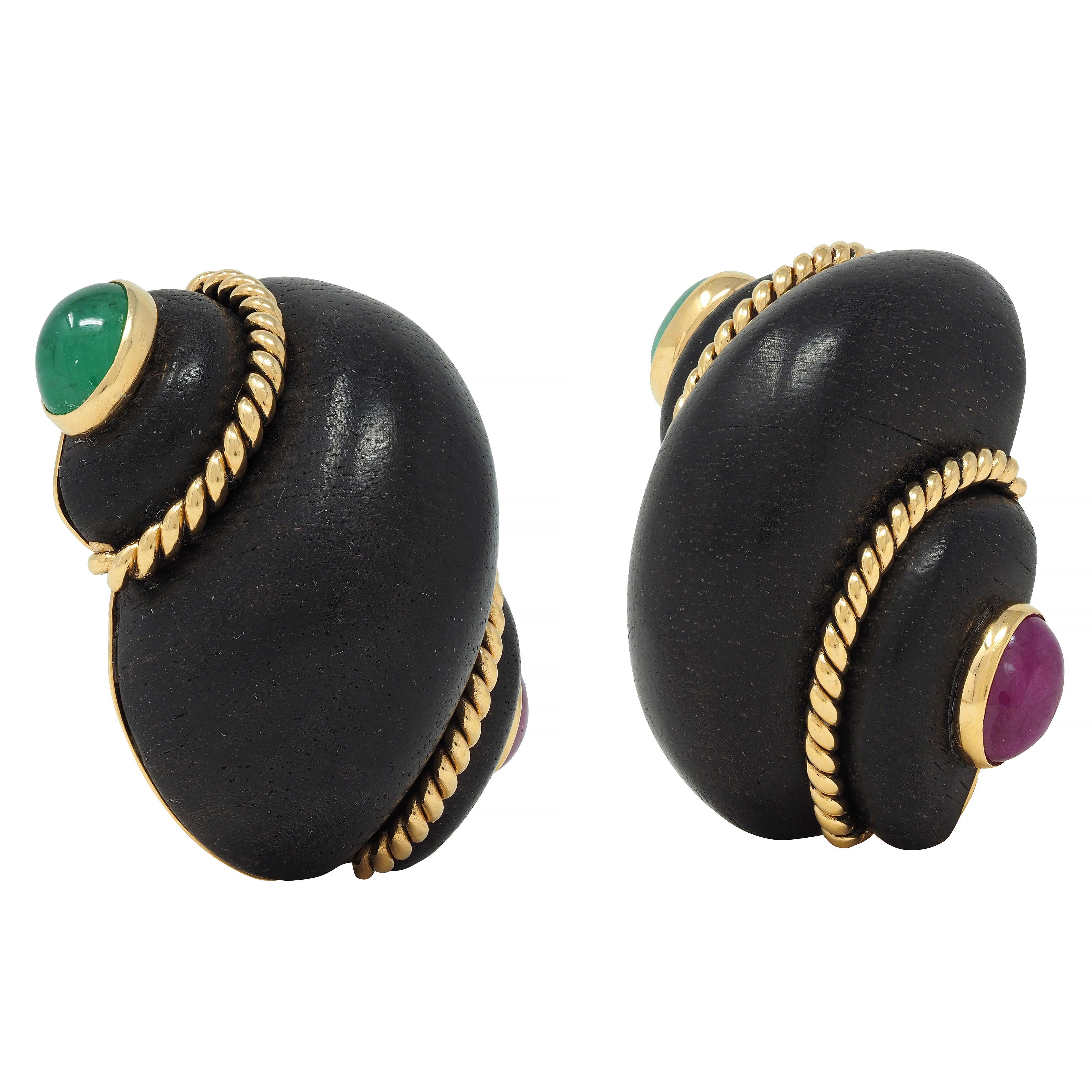 Designed as carved wooden shells with arching segments - dark brown with smooth grain
Wrapped with twisted rope motif yellow gold wire and terminating with gemstones
Comprised of bezel-set oval-shaped ruby and emerald cabochons 
Rubies weigh