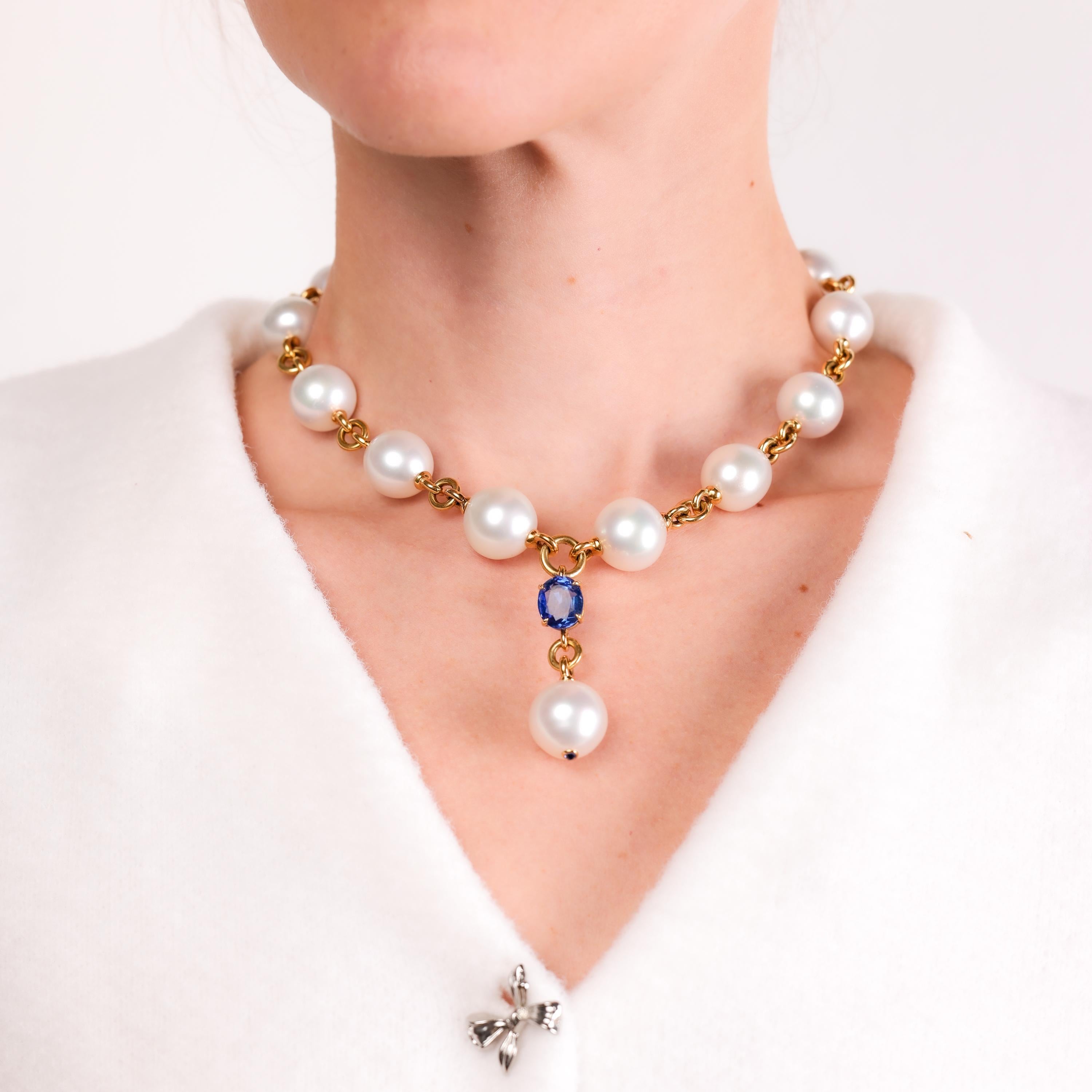 A luxurious Verdura Y drop necklace showcasing a 5.60-carat blue sapphire, 13 luminous South Sea pearls, and gleaming 18k yellow gold craftsmanship.

Brand: Verdura
Center stone: Oval cut blue sapphire 
Weight: Approximately 5.60 carats
Accent