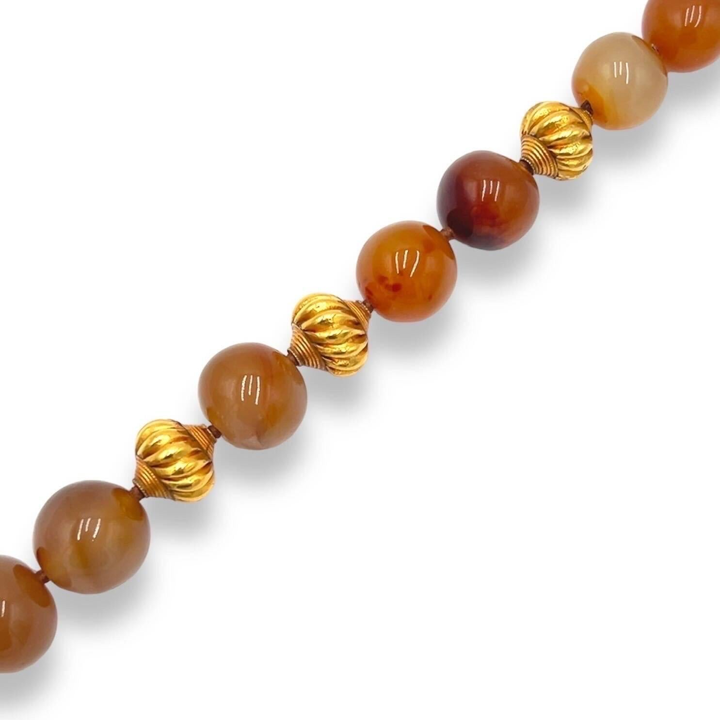 An 18 karat and high karat yellow gold and agate necklace, Verdura.  Designed as a strand of thirteen (13) amber colored near round agate beads measuring between approximately 19.8 and 23.1 mm punctuated with six (6) stylized turban shaped high
