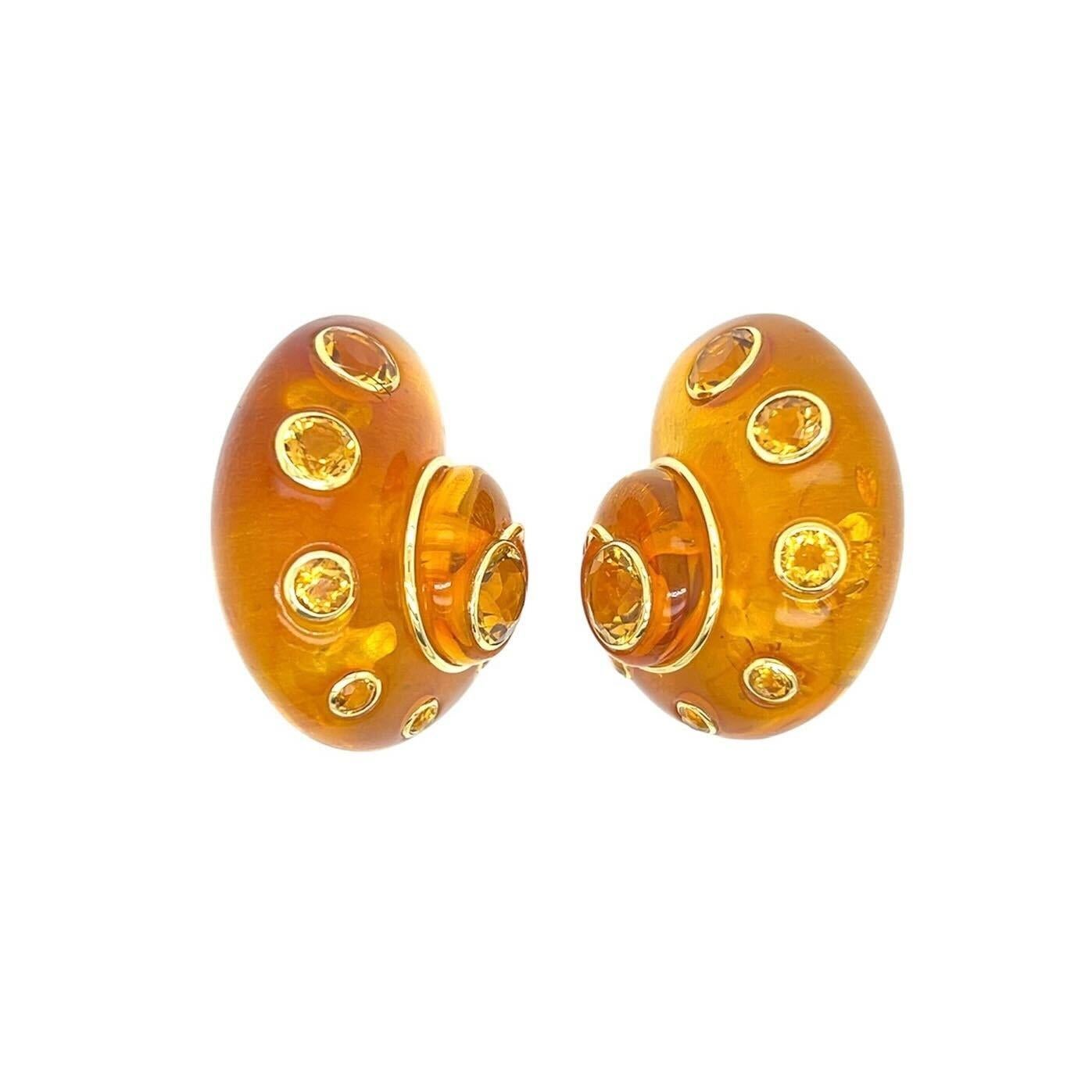 A pair of 18 karat yellow gold, amber and citrine earclips, Verdura.  Each earclip designed as a nautilus shell of amber applied around the spiral with eight  bezel set round faceted citrines ranging in size from approximately 1.93 to 8.09 mm,