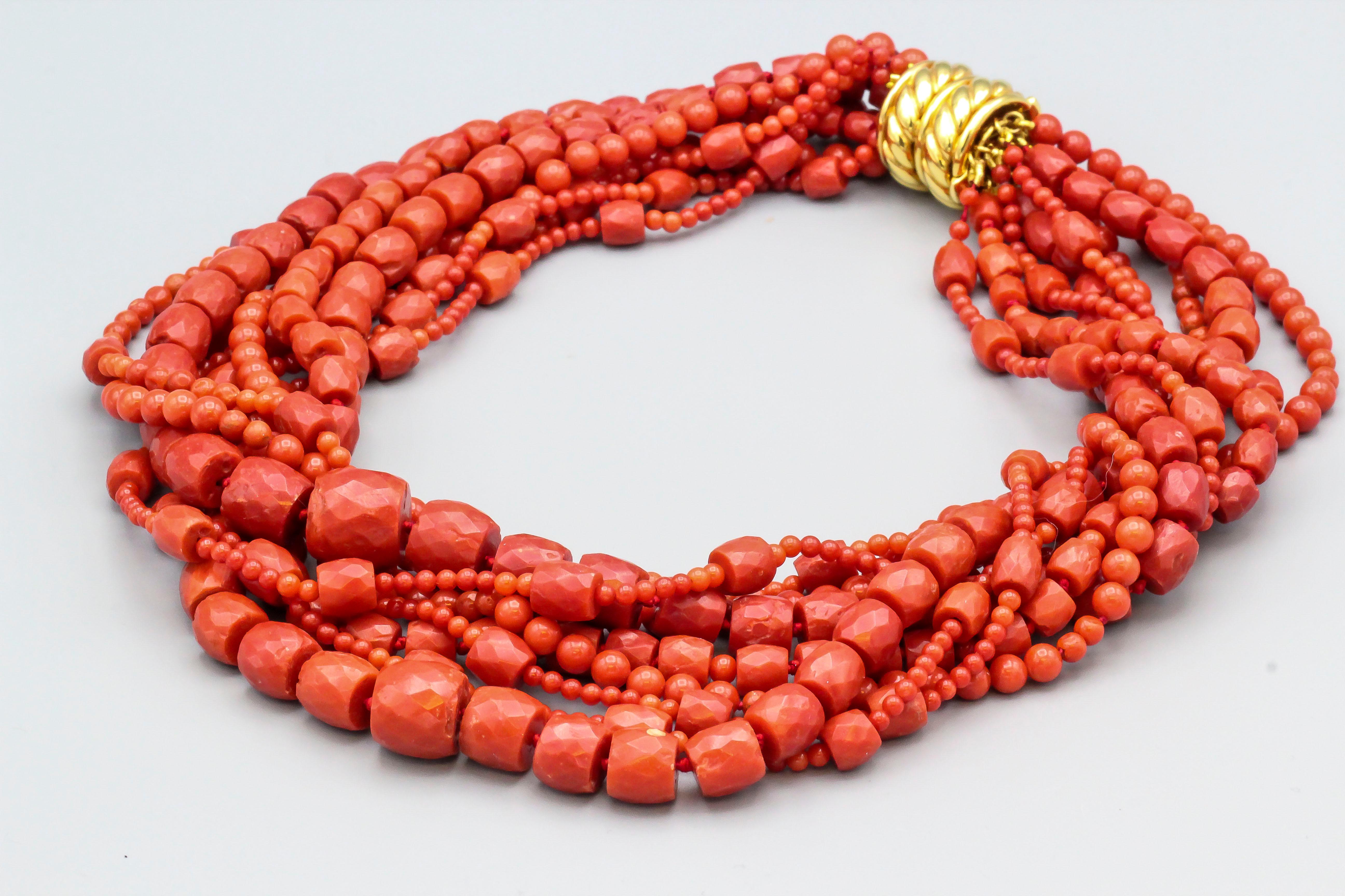 Fine coral and 18K yellow gold torsade necklace by Verdura circa 1970-80s. It features 9 strands of rich red coral beads, held on by an 18K yellow gold clasp. Strands are of varying sizes and diameters, ranging from 3mm to 14mm. Approx. 18
