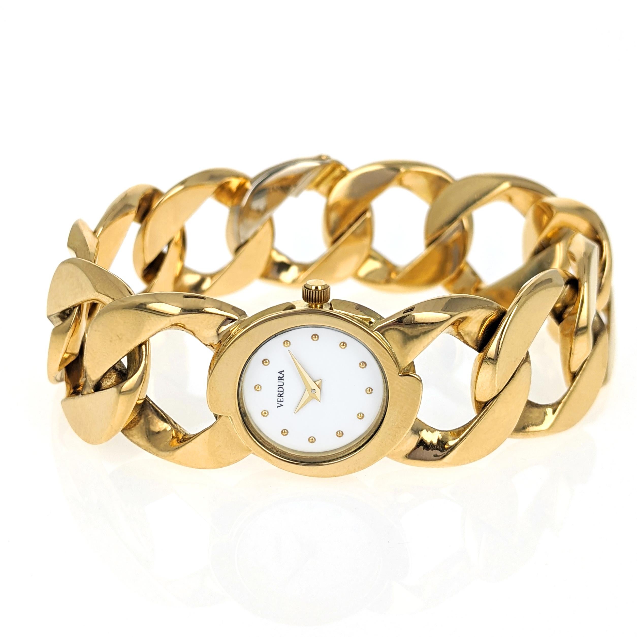 This 18 karat yellow gold watch features Verdura's classic curb link bracelet with a round white lacquer dial and gold dot hour markers. The back of the case is inscribed 
