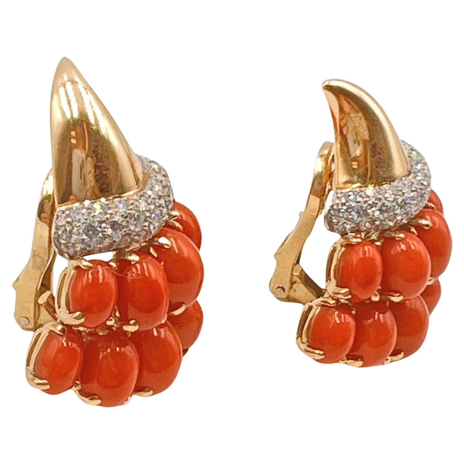 Cornucopia design earrings by Verdura in 18k yellow gold and platinum set with coral and diamonds.  Polished gold tops with a central platinum rim which is pave-set with sixty-six round brilliant-cut diamonds weighing approximately 1.32 total