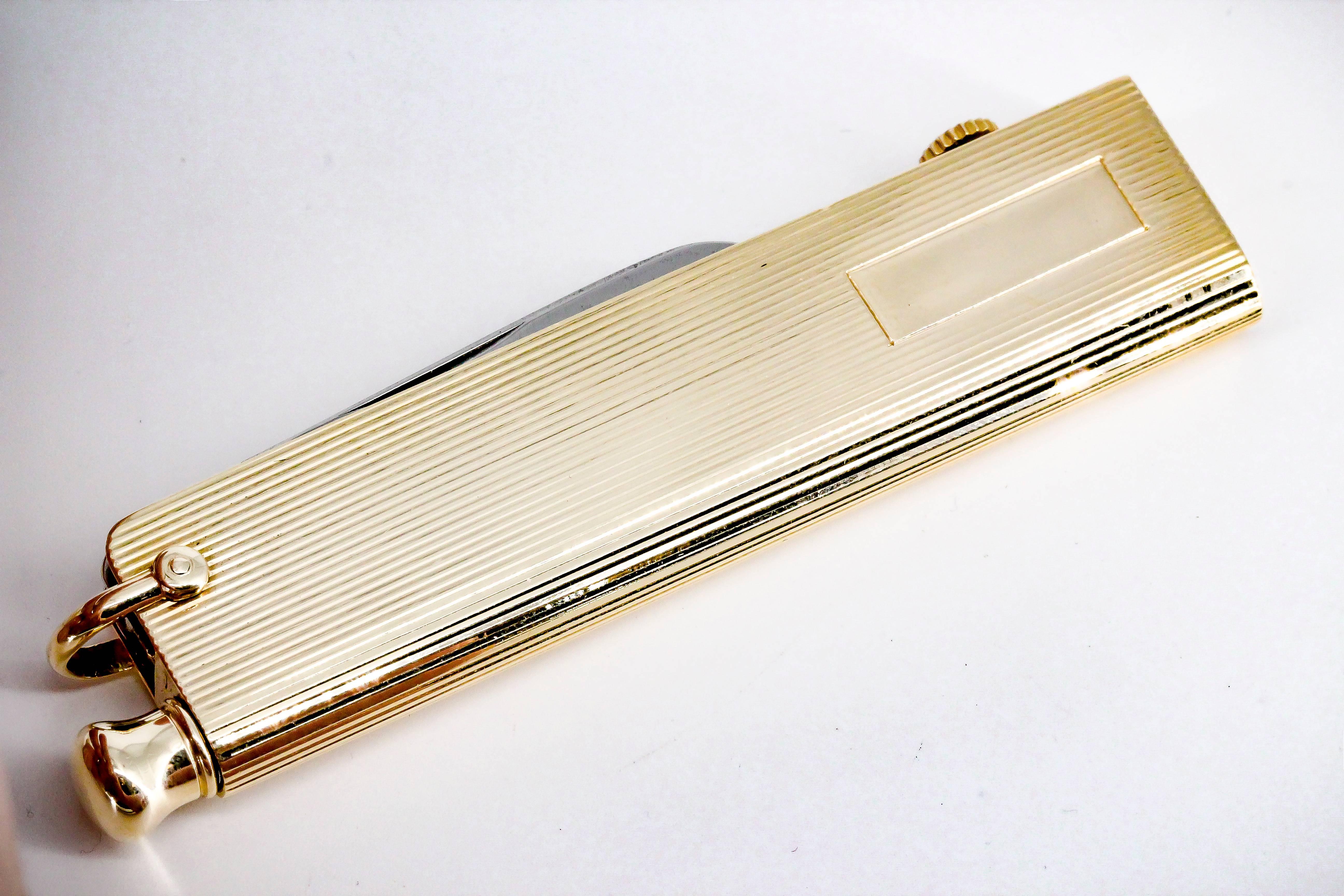 Rare and unusual 14K yellow gold utility tool by Verdura. It features a folding knife, a hidden pencil that slides out of the bottom, a folding key that can be cut to size, and a clock on the top. Outer case is ribbed throughout the outside.