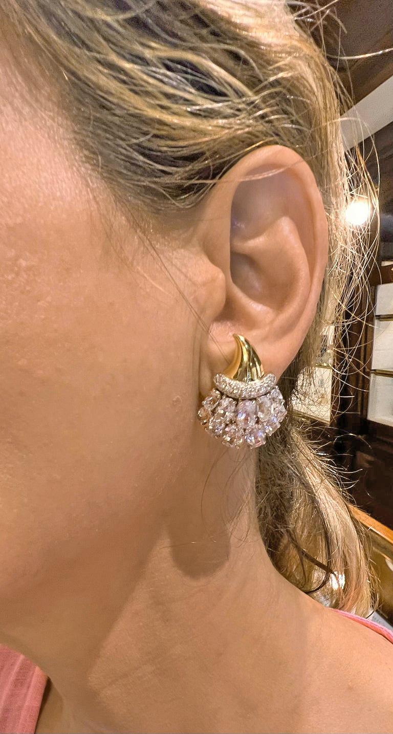Verdura cornucopia earrings in 18k yellow gold set with white topaz and diamonds.  Polished gold tops with a central rim pave-set with sixty-eight round brilliant-cut diamonds weighing approximately 1.38 total carats.  The bottoms are set with