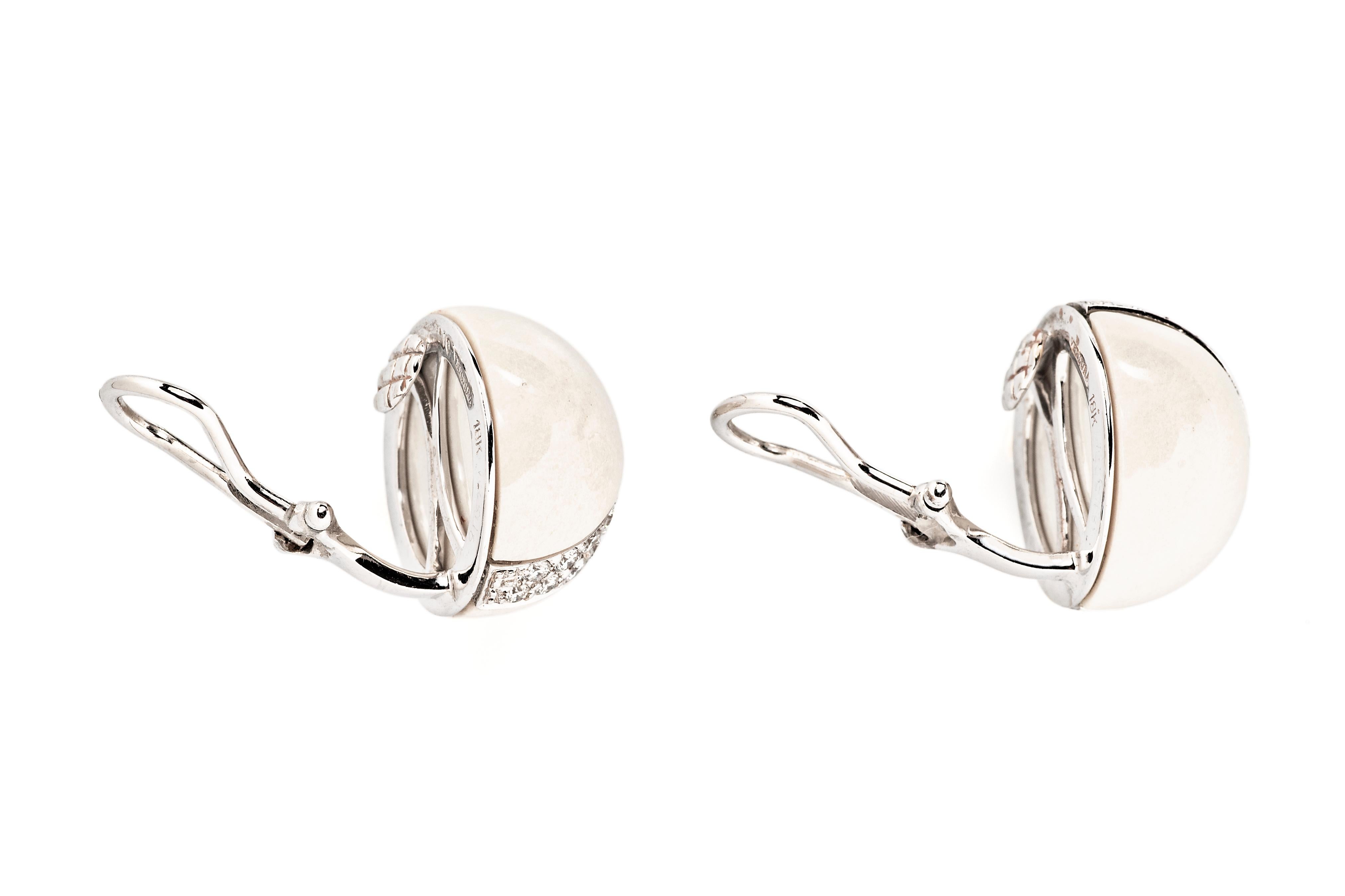 Ces clips d'oreilles Verdura, qui constituent un élément de base de la joaillerie chic, présentent un dôme en pierre dure blanche traversé par une bande de diamants ronds brillants.

Le diamètre est de 0,625