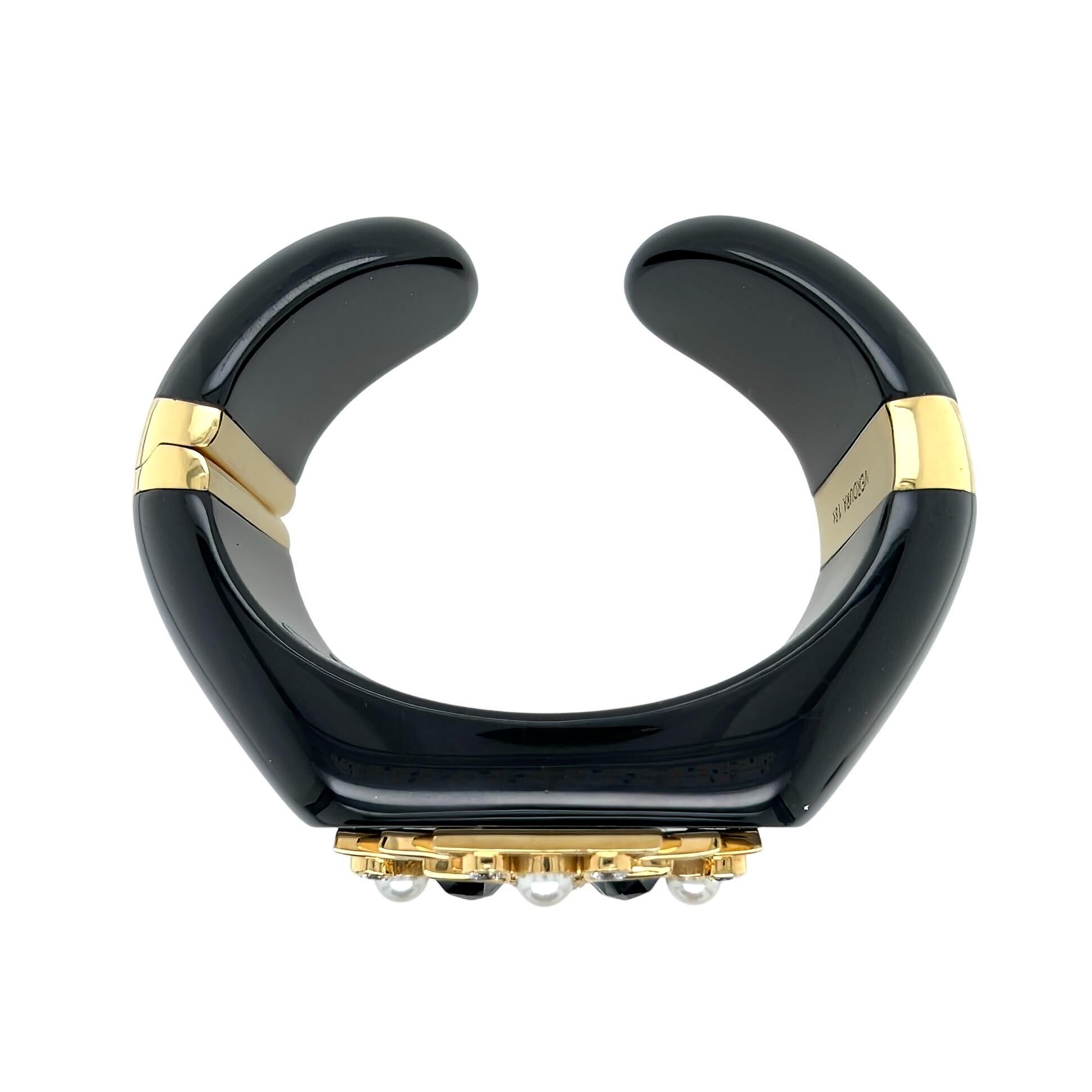 An 18 karat yellow gold, black jade, pearl, black diamond and diamond bracelet, Verdura.  Designed as a hinged open baked cuff of black jade applied with a gold Maltese cross decorated with four pear shaped black diamonds, four pearls, one oval