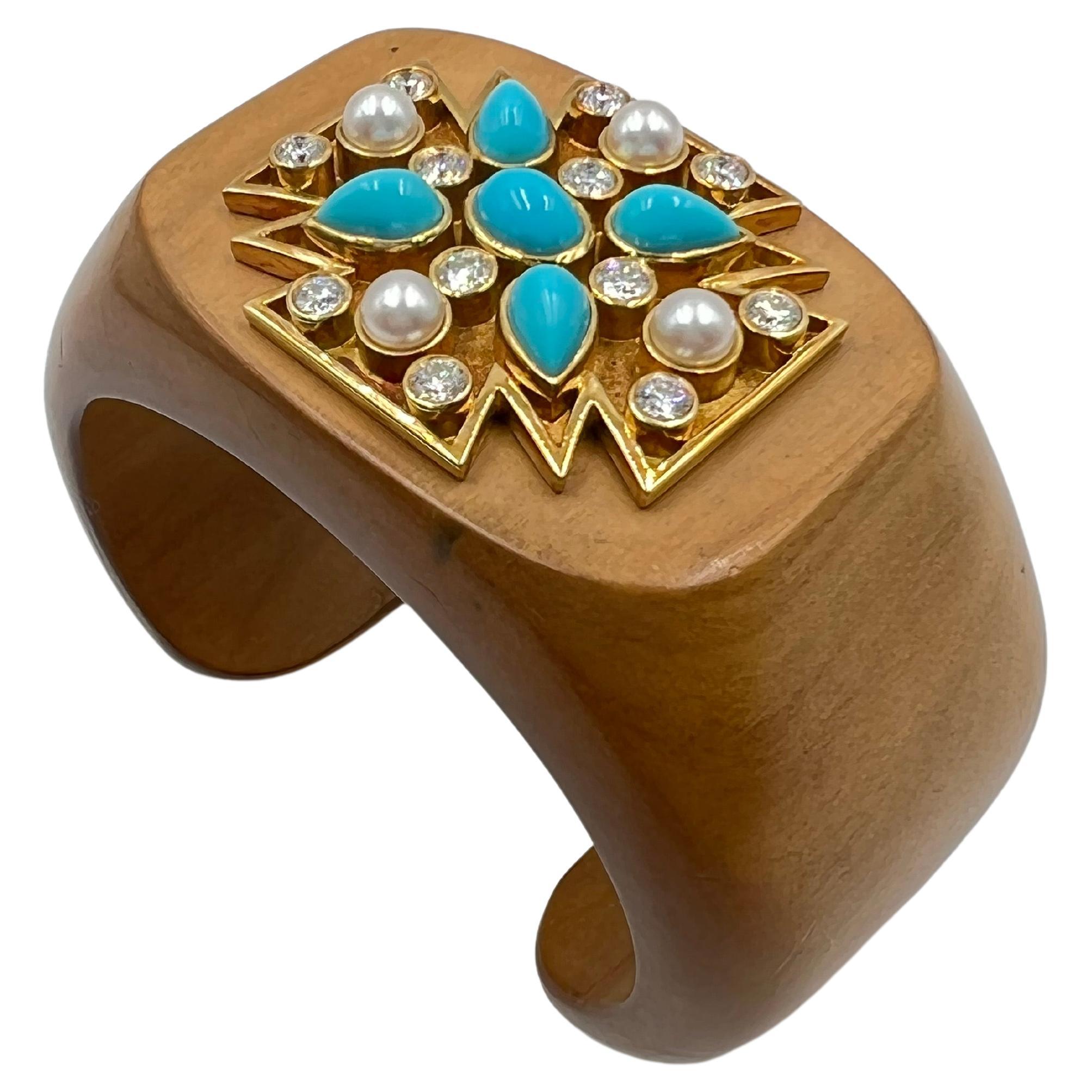 Carved sandalwood cuff featuring an 18k yellow gold Maltese cross motif. The cross centers an oval-shaped cabochon-cut turquoise surrounded by four pear-shaped cabochon-cut turquoise, four cultured pearls and twelve round-cut diamonds.  Signed