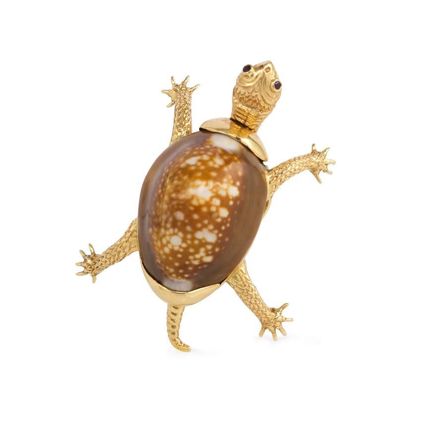 A mid-century engraved gold and cowrie shell brooch in the form of a turtle with ruby eyes, in 14k. Verdura

In superb condition