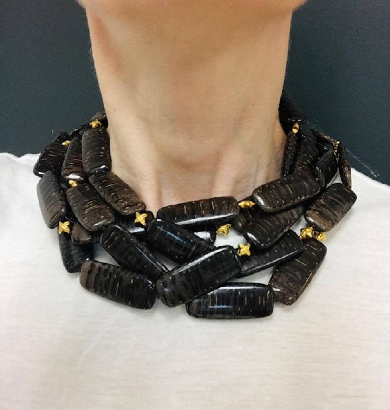 This  wood Verdura necklace takes an unexpected material and turns it into something with both presence and personality. The design features rows of oblong, glossy wooden beads with a deep espresso tone and natural striping. The beads are arranged