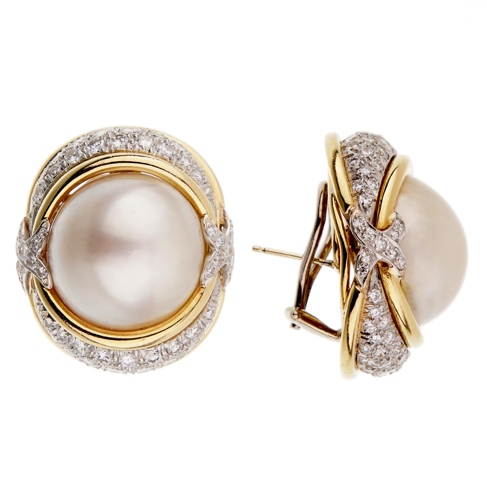 A fabulous pair of Verdura earrings each centering a mabe pearl adorned with platinum ribbons showcasing 4.20ct appx of round brilliant cut diamonds. The earrings measures 1