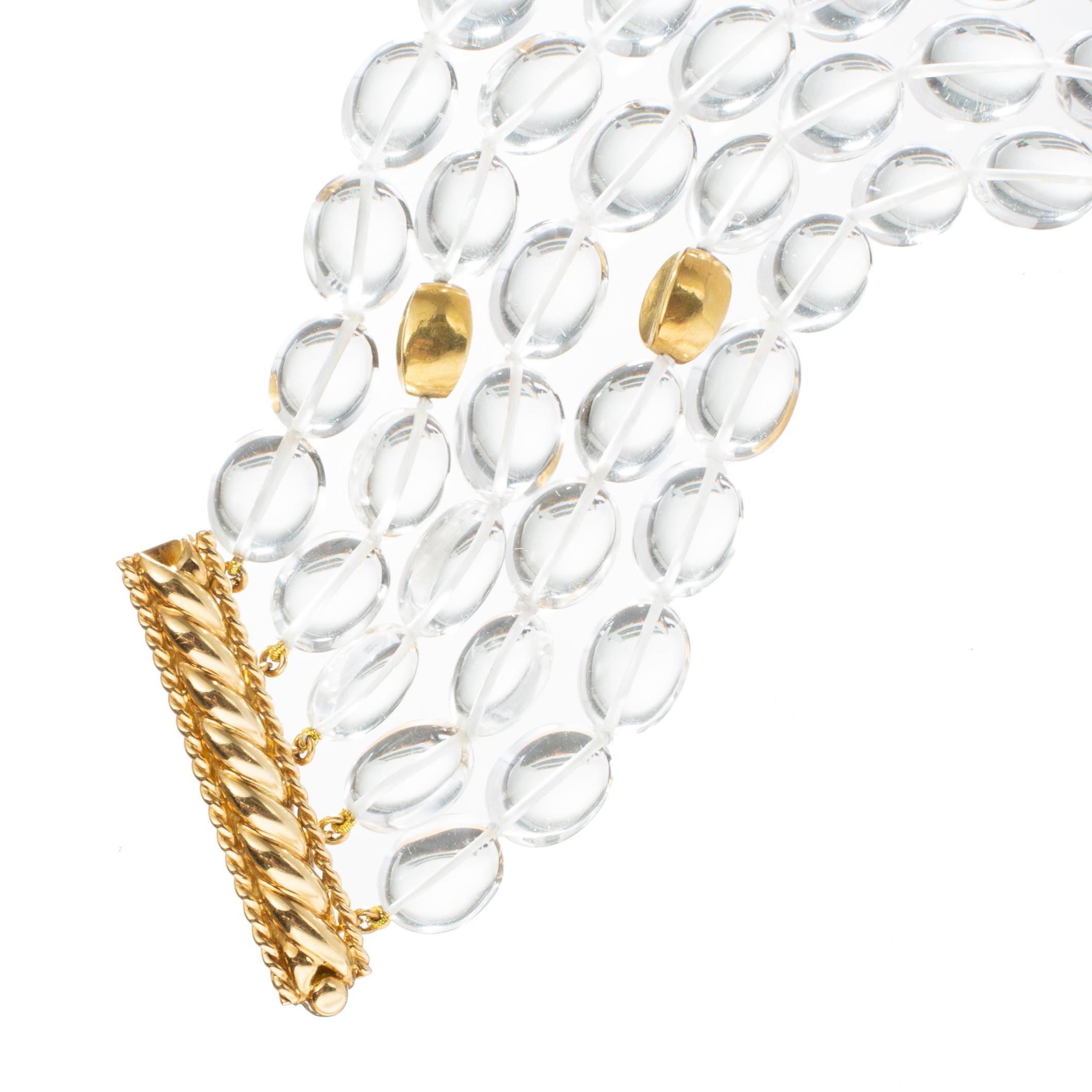 Verdura five-strand bead bracelet, featuring oval, polished, colorless, natural quartz rock crystal beads measuring 11-14 x 10-11mm each interspersed with five 18k yellow gold beads.  The 18k yellow gold elongated bar-form clasp has a rope design