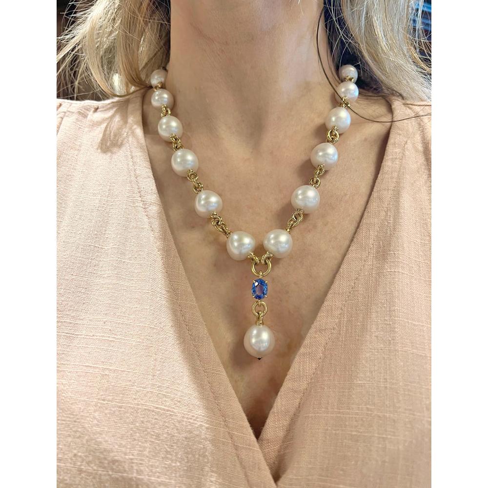 South Sea pearl and sapphire 'Y' drop necklace, composed of fourteen cultured South Sea pearls connected by 18k yellow gold links with a pendant consisting of a prong-set oval faceted Ceylon sapphire to a drop-shaped cultured South Sea pearl with a